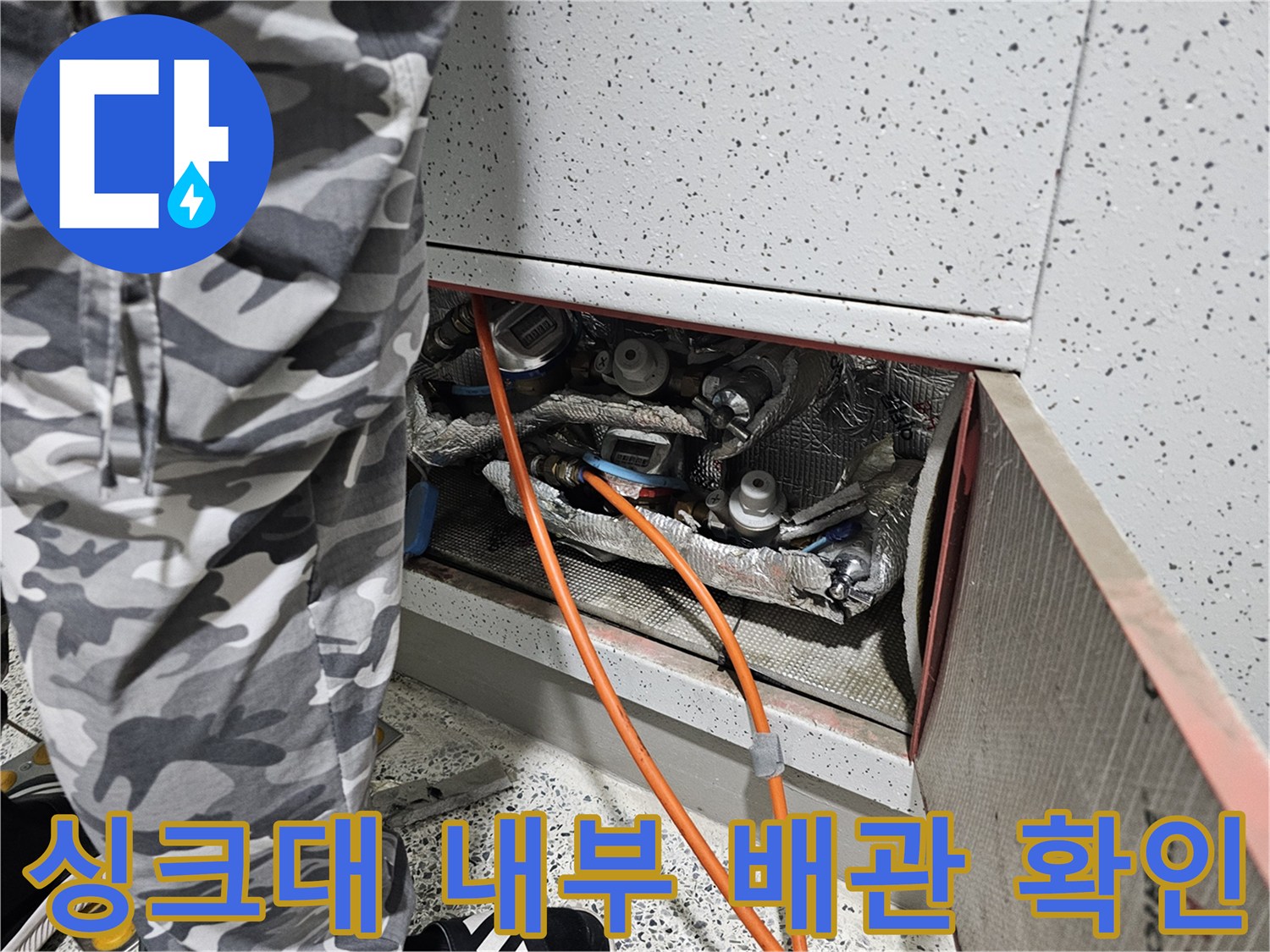 싱크대 하부장 내부에 노출된 배관과 연결 부위의 모습입니다.