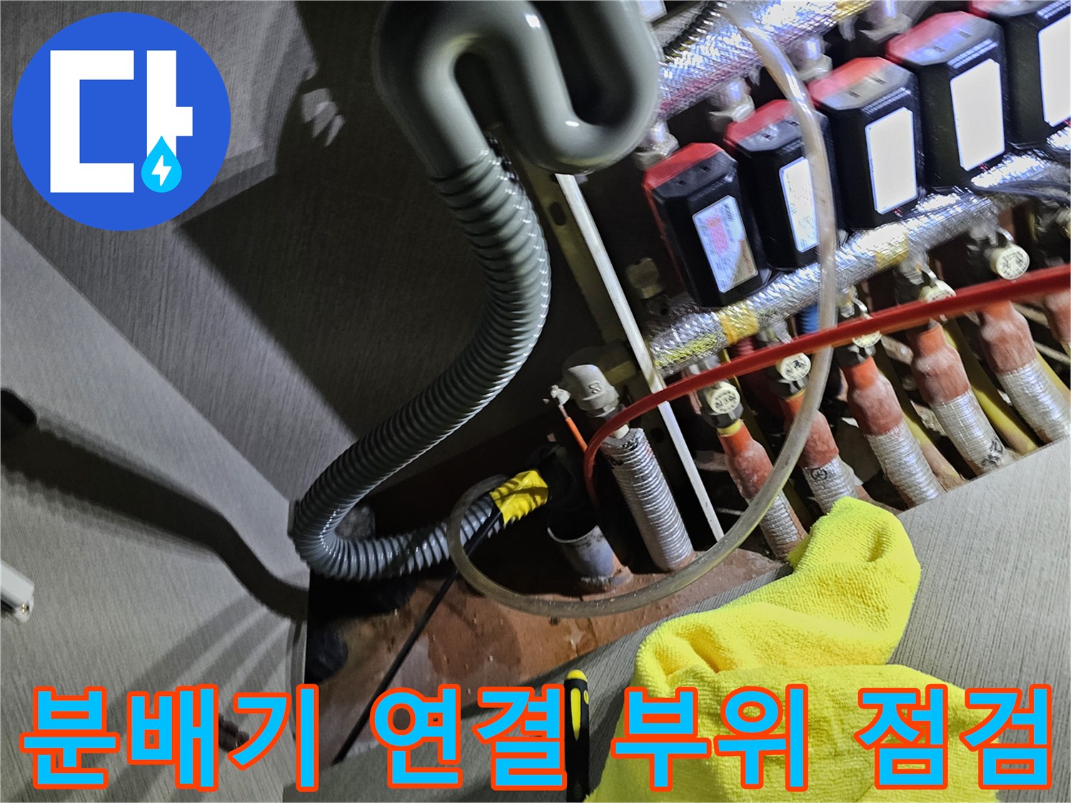 싱크대 하부장 내부의 분배기와 배관들이 복잡하게 얽힌 구조를 촬영했습니다.