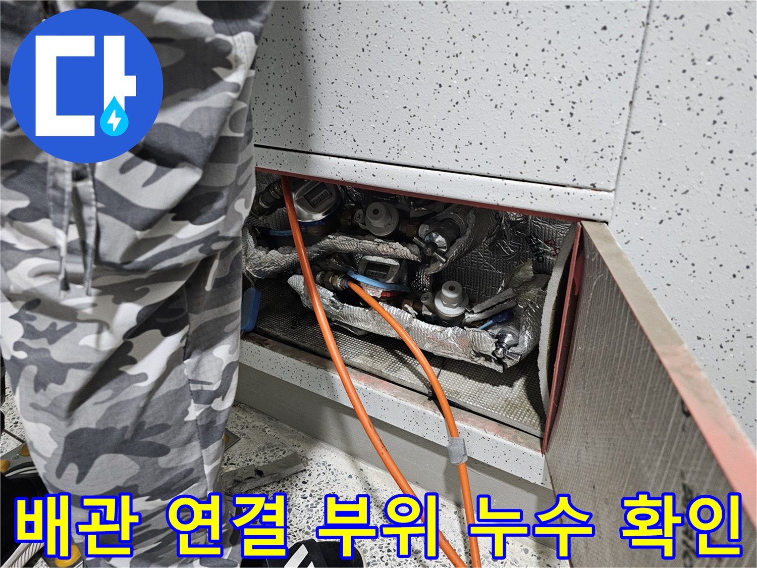 주황색 호스가 연결된 싱크대 하부 배관의 보온재 마감 상태