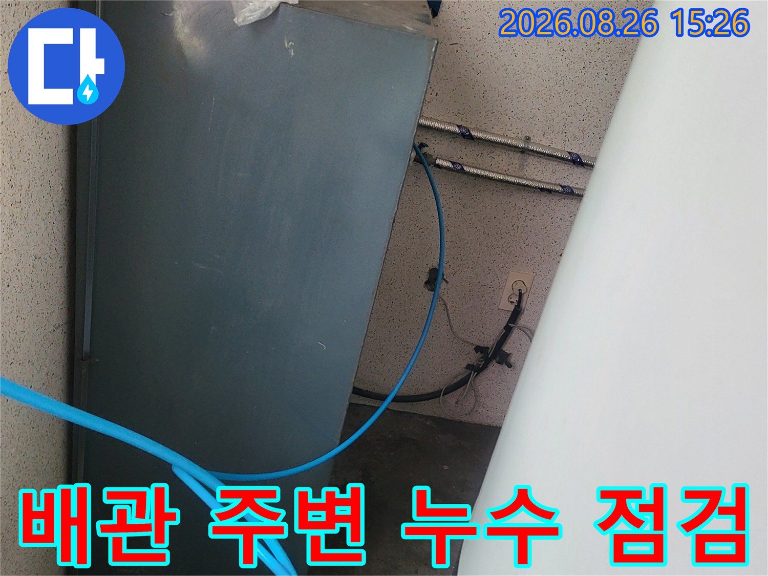 금속 배관과 파란색 호스가 연결된 설비 구조-누수 탐지 중