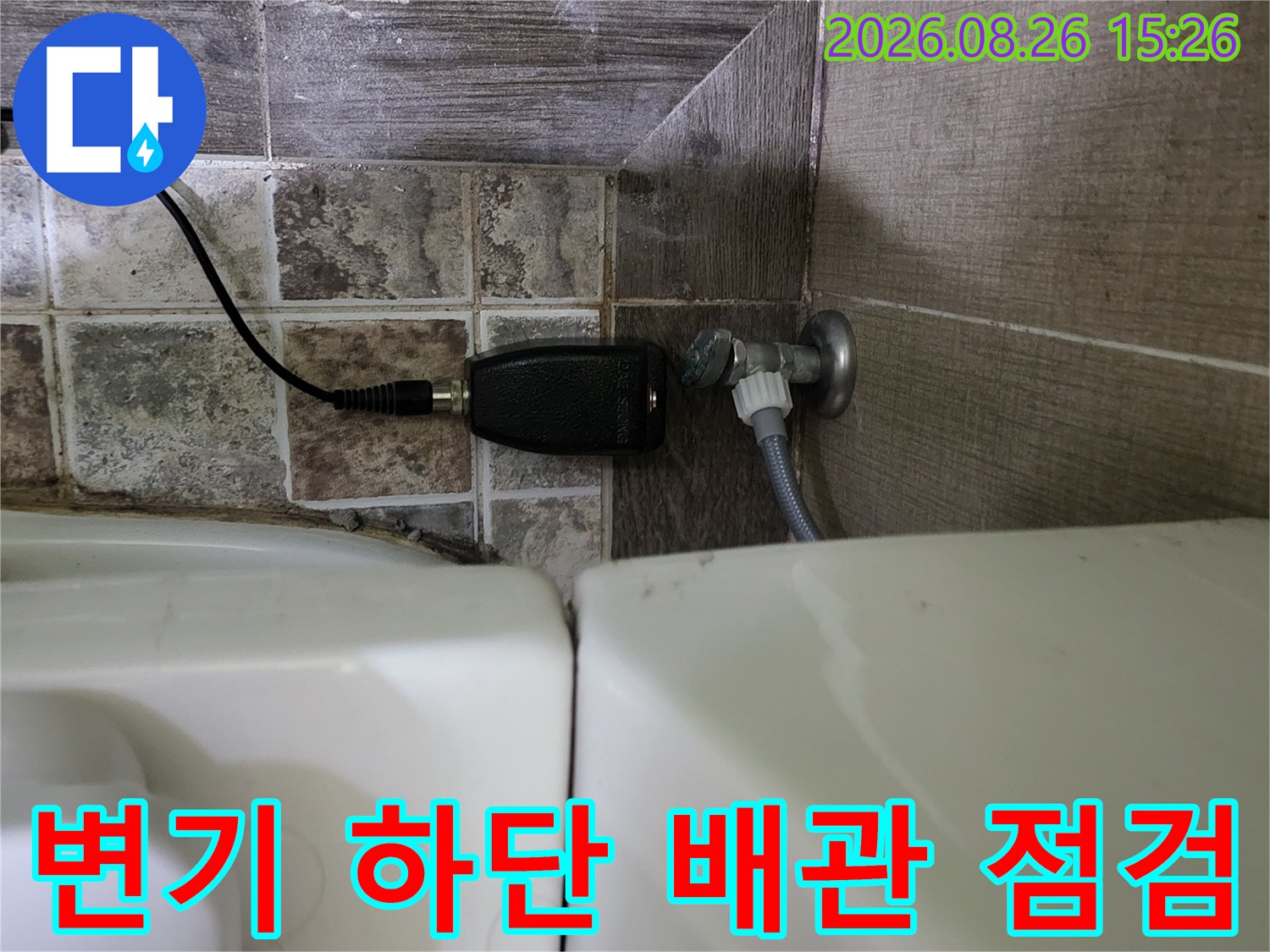 변기 옆 배관 부위에서 가스 탐지기를 연결하여 누수를 정밀하게 확인하는 모습입니다.