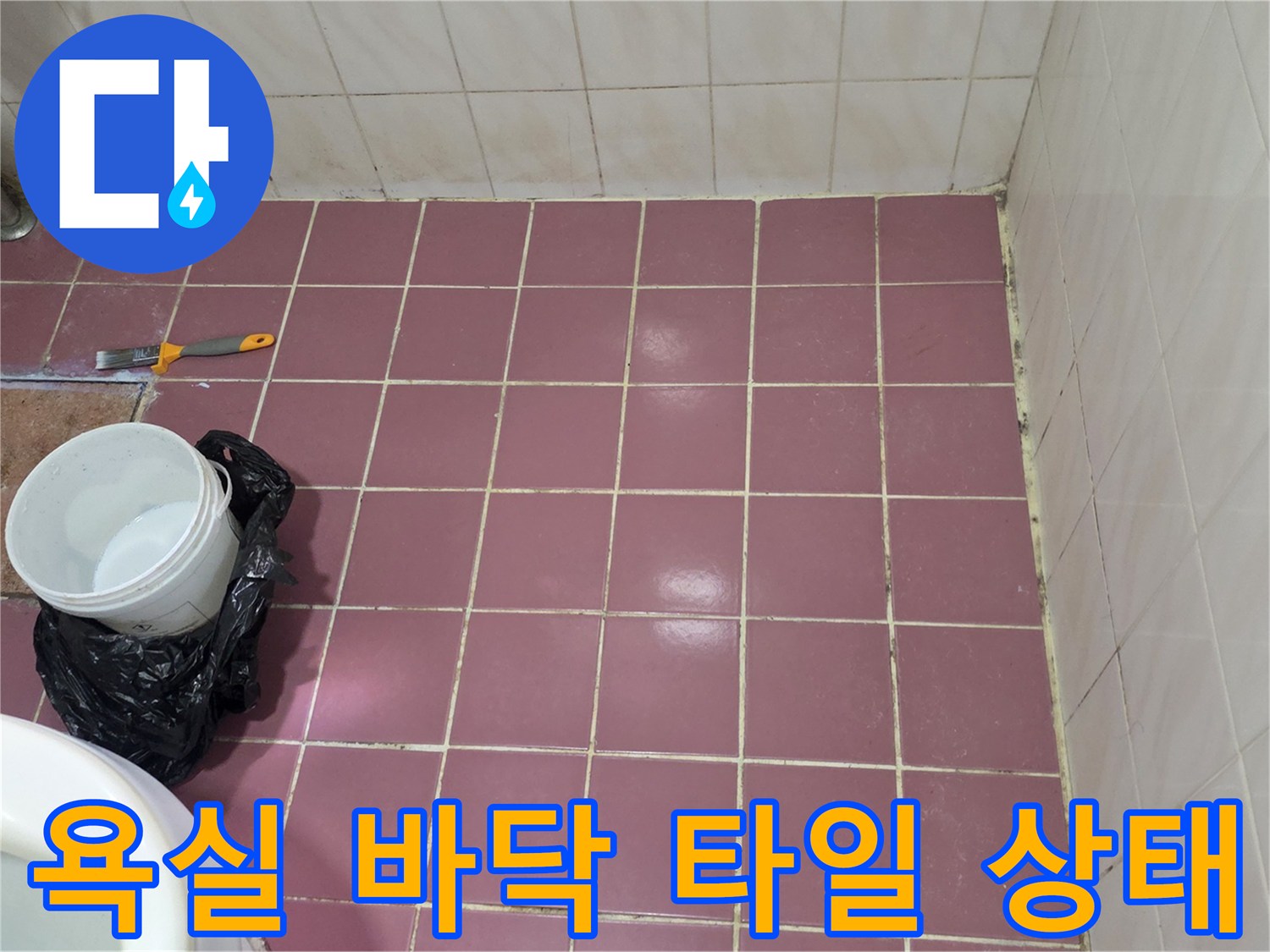분홍색 욕실 타일과 작업 도구가 놓여 있는 모습
