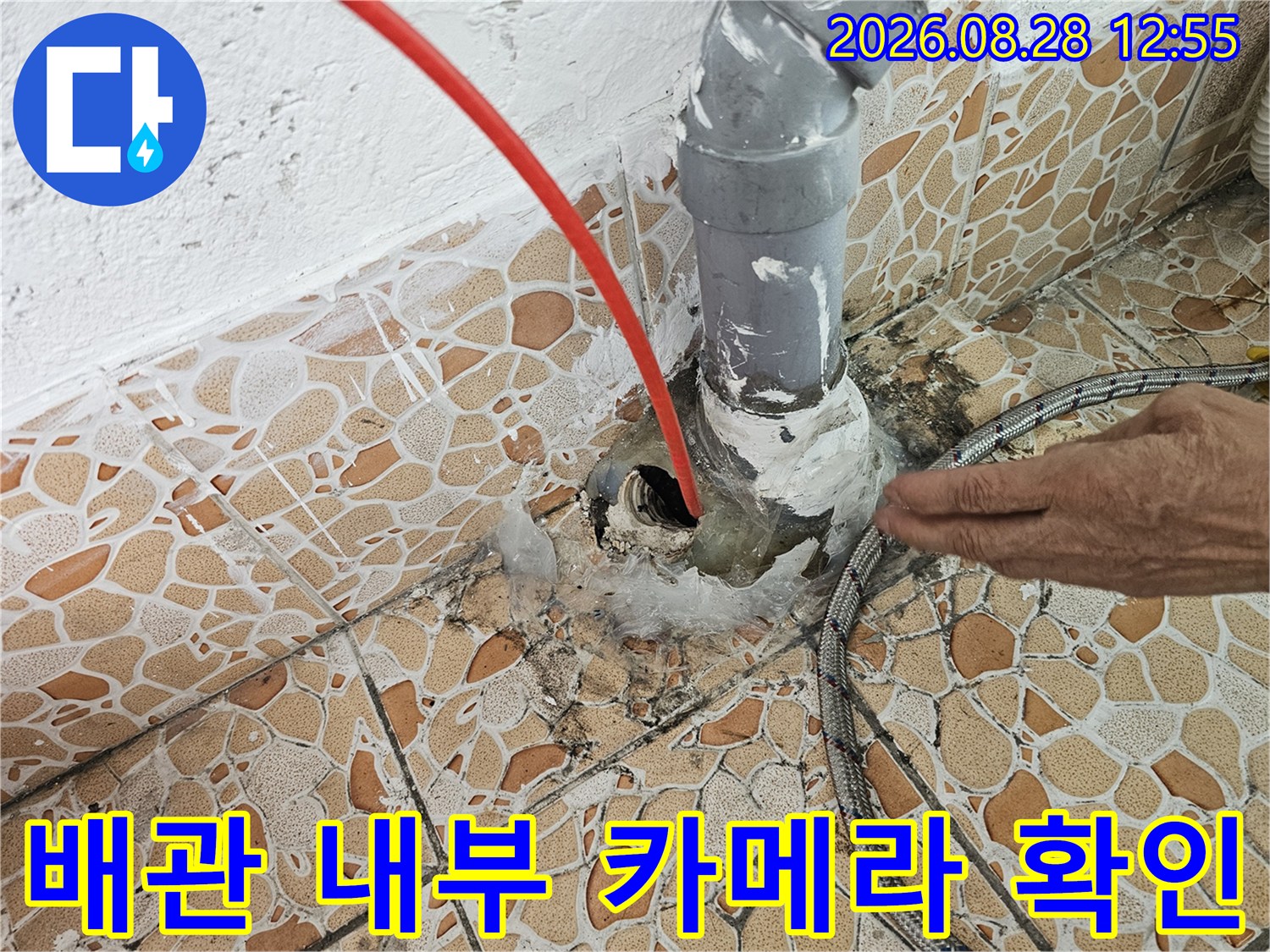 배수관 내부에 투입된 빨간색 내시경 선-배관 내부의 결함을 찾기 위한 작업입니다.