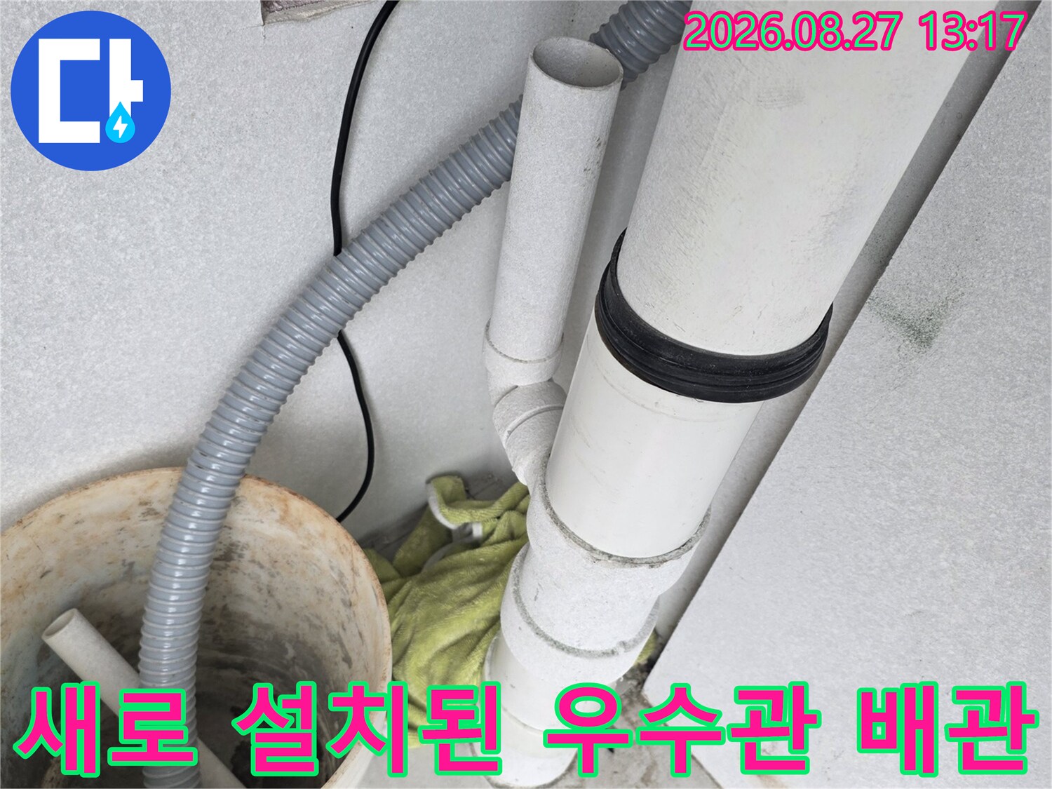 교체 완료된 흰색 우수관과 연결 부속의 근접 촬영본입니다.