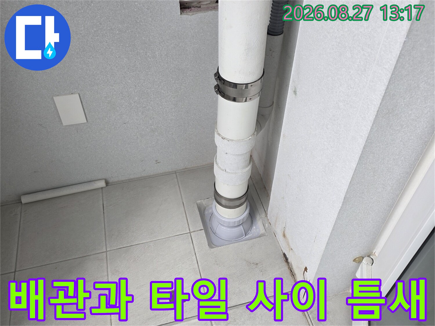 우수관 배관의 연결 부위와 주변 타일 상태를 보여줍니다.