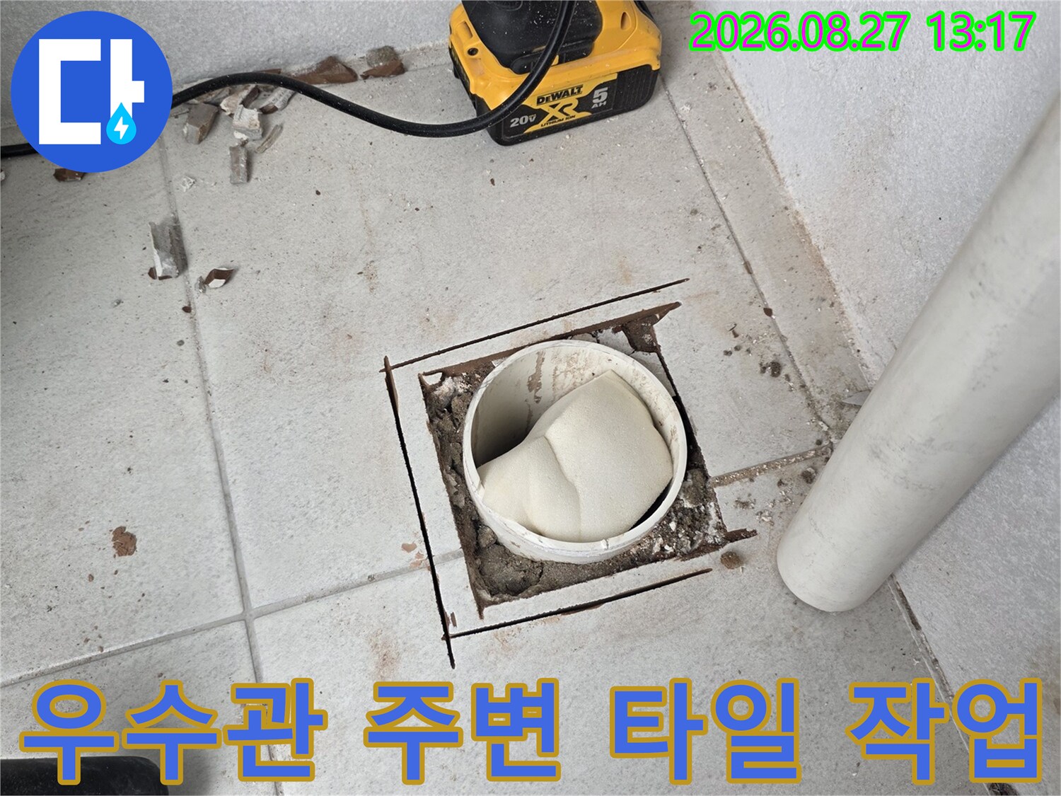 우수관 주변의 젖은 타일과 배관 노출 부위입니다.