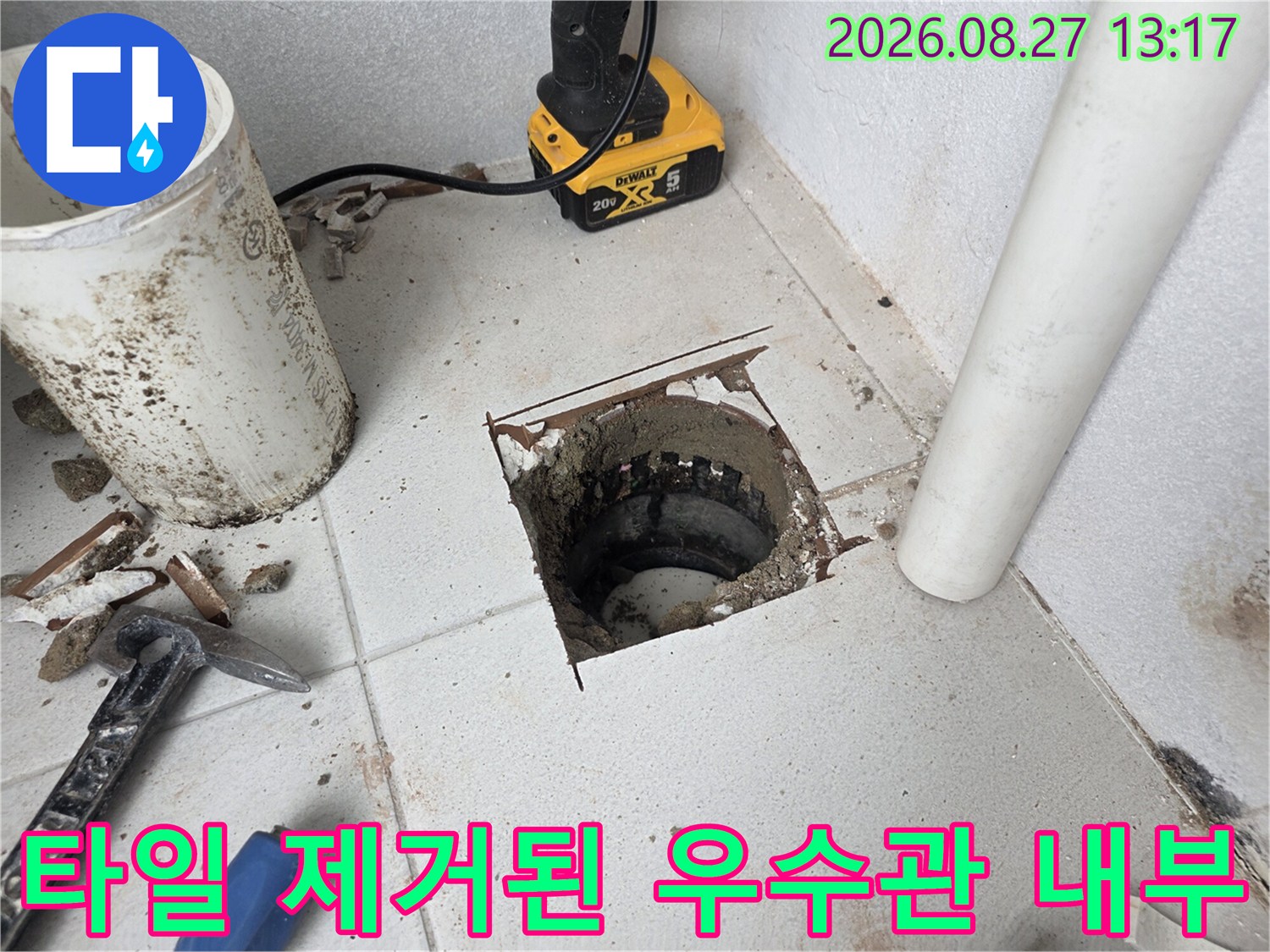 타일을 걷어내고 드러난 우수관 배관의 노출된 연결 부위 모습입니다.