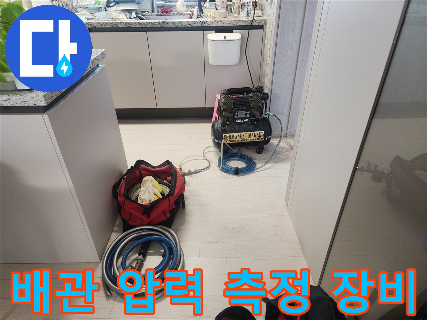 싱크대 하단부의 공압 테스트용 컴프레서와 호스들