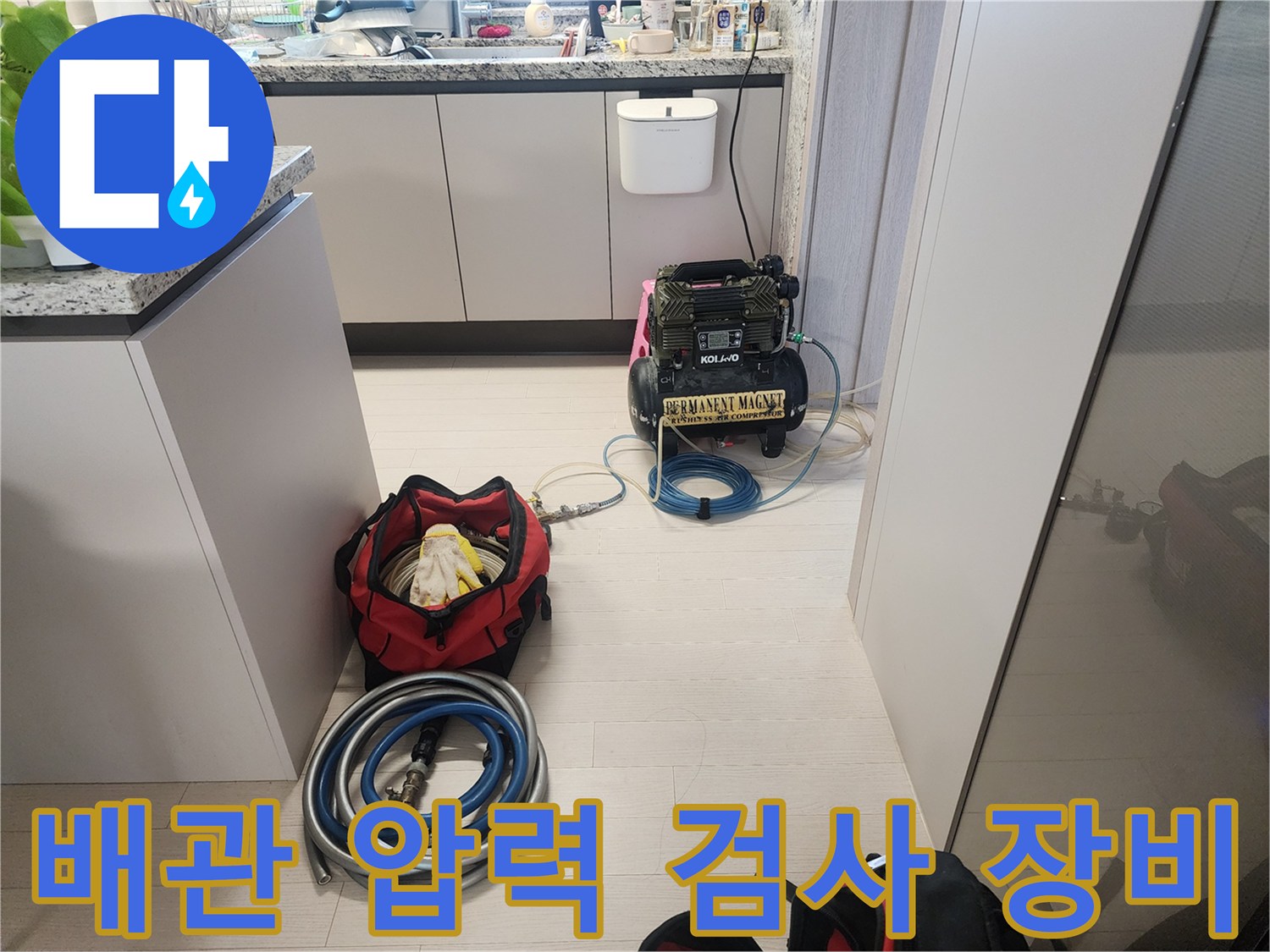 싱크대 하부 공간에 배치된 공압 테스트용 콤프레셔와 호스