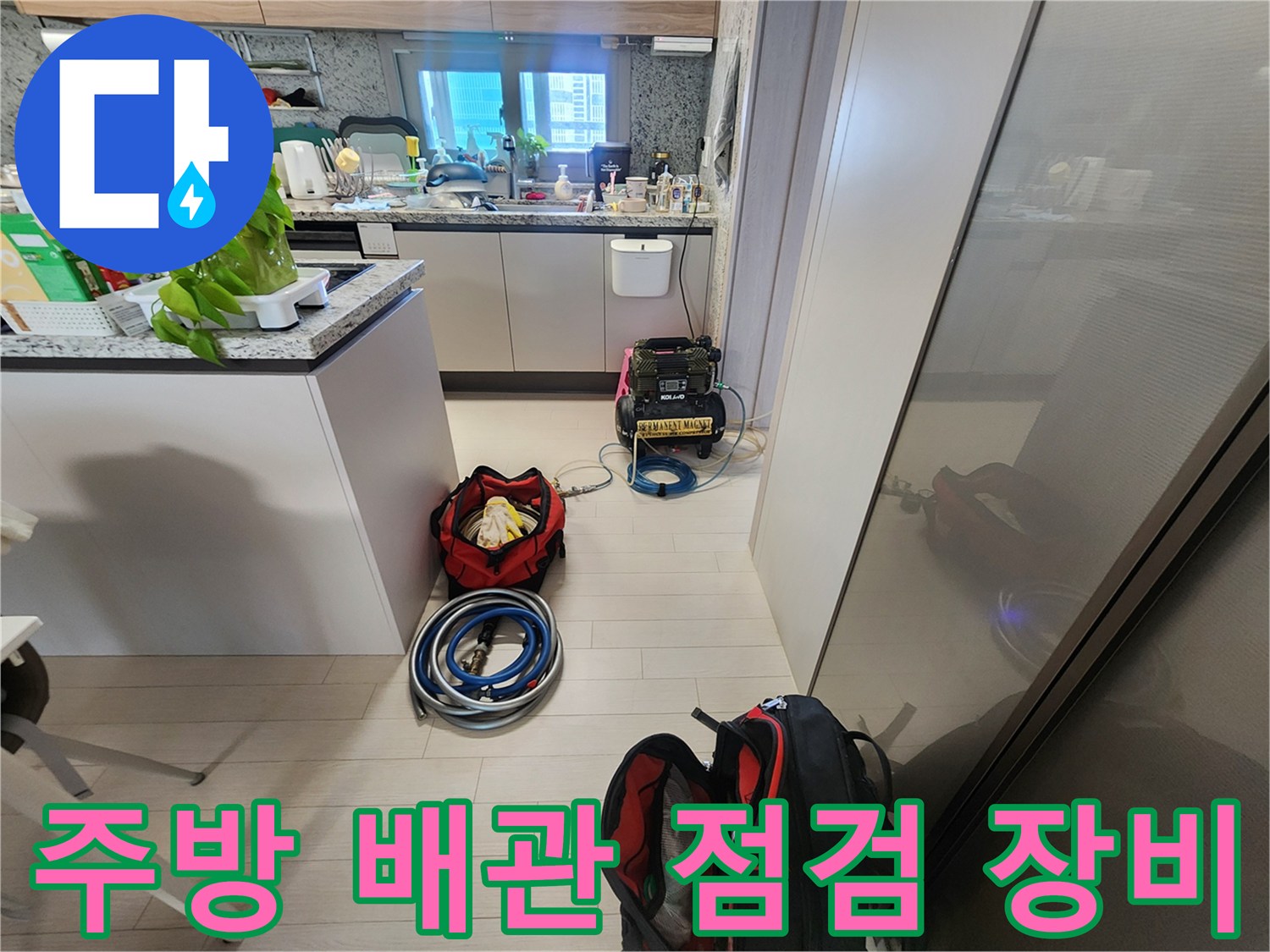 싱크대 하부장 주변에 배치된 누수 탐지용 디지털 압력 게이지와 각종 검사 장비들