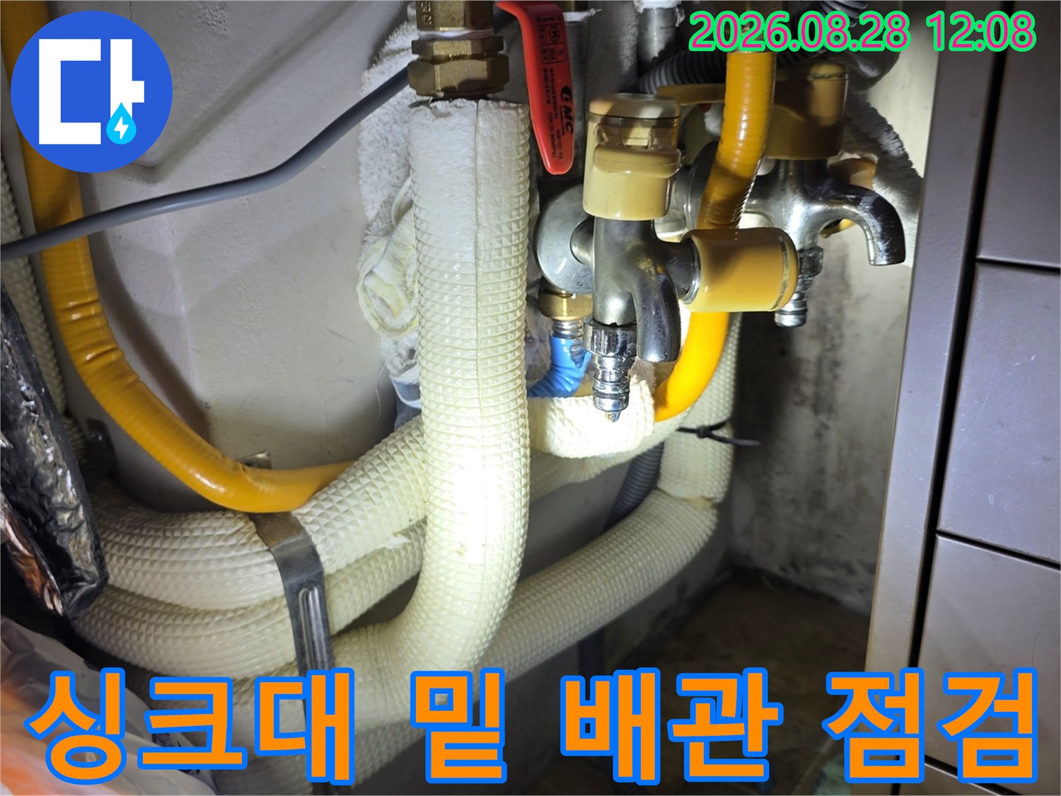 복잡하게 얽힌 싱크대 하부 배관과 금속 밸브 부위 근접 촬영