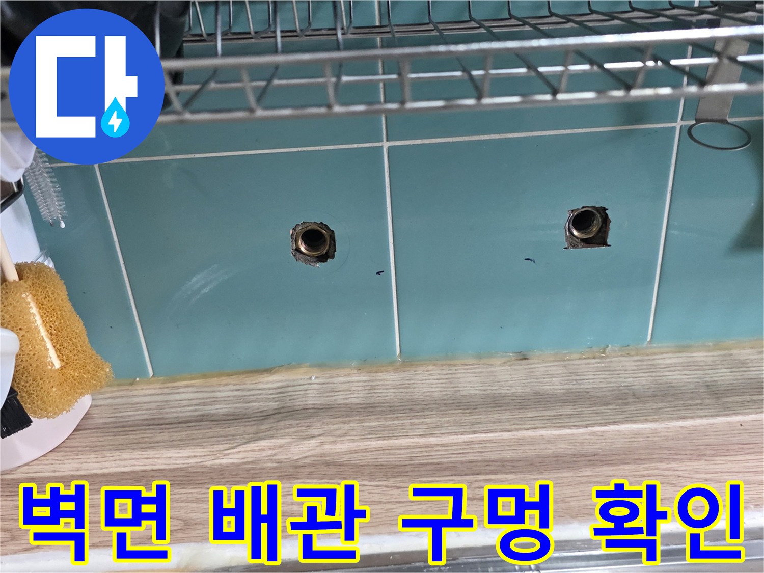 싱크대 하부 벽면에 노출된 두 개의 수도 배관 입구