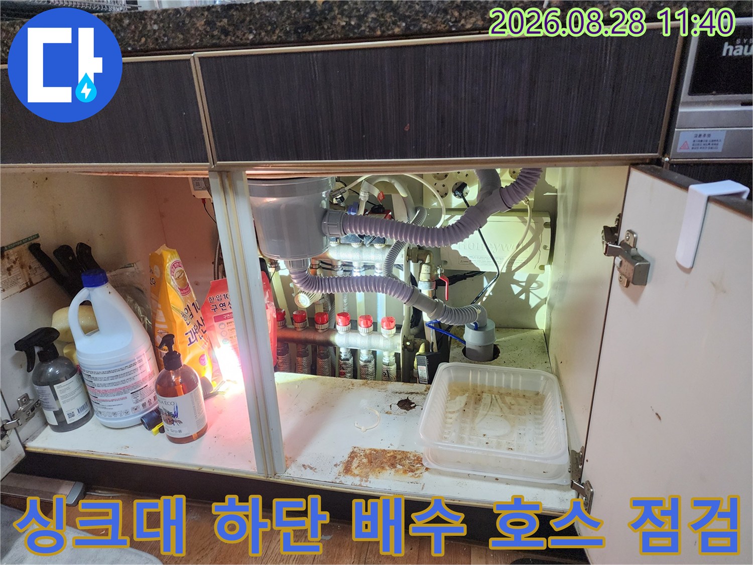 싱크대 밑바닥 배관 연결 부위와 주변 세척제 모습