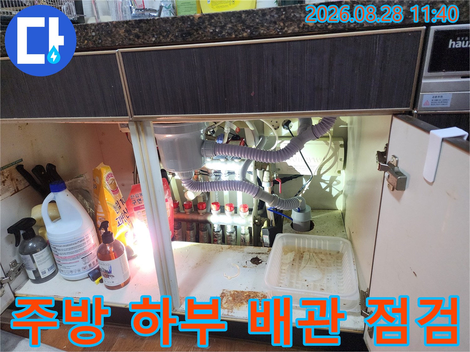 싱크대 하단부의 에어컨 드레인 호스와 연결된 배관 부위 상세 모습