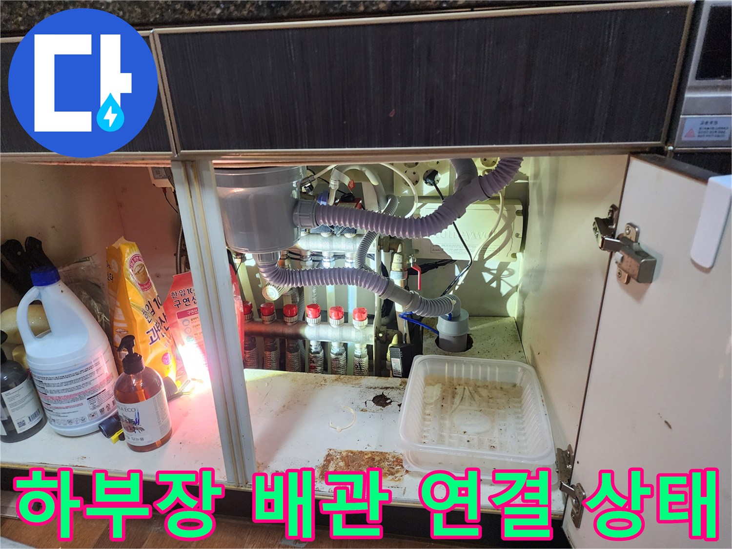 싱크대 하단에 설치된 에어컨 응축수 배출용 자재와 배관 연결 부위