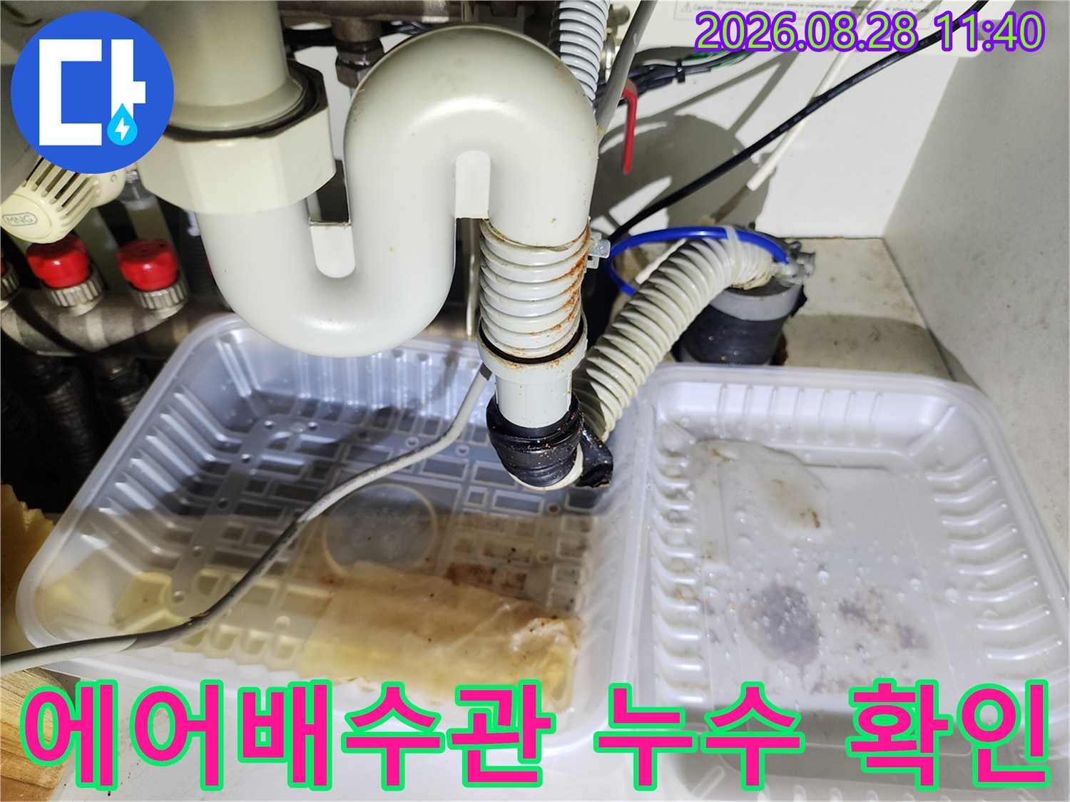 에어컨 드레인 호스와 싱크대 배관의 연결 상태를 점검하는 장면입니다.