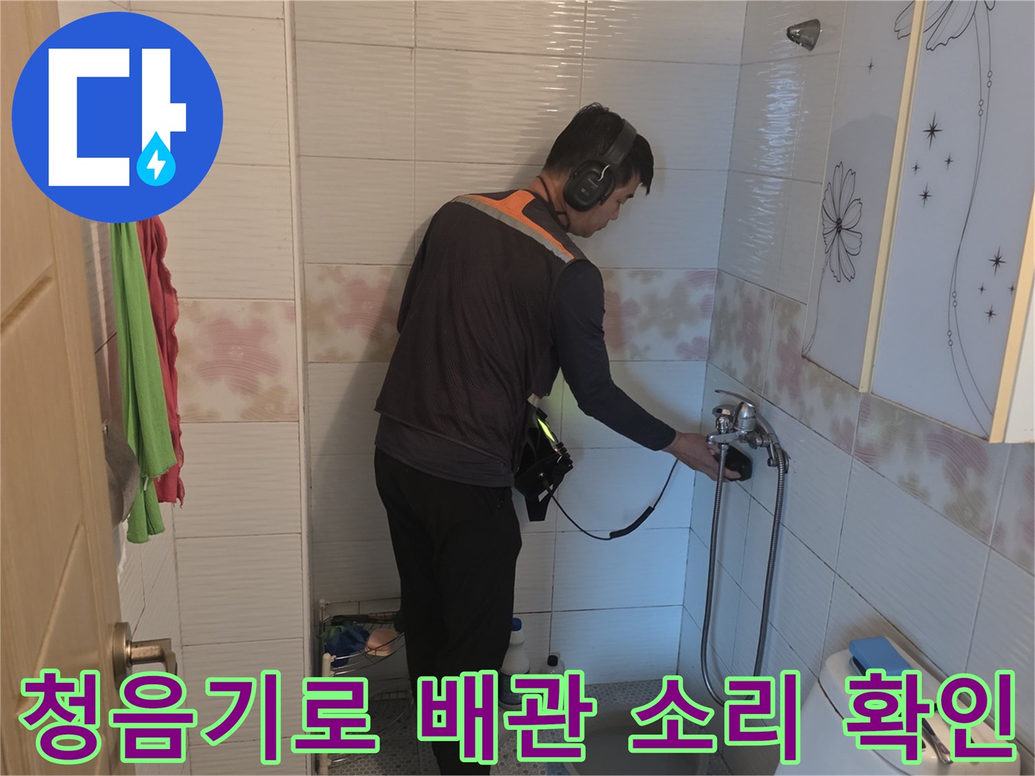 세면대 아래쪽 배관에서 나는 물소리를 찾기 위해 청음 탐지기를 사용하는 모습