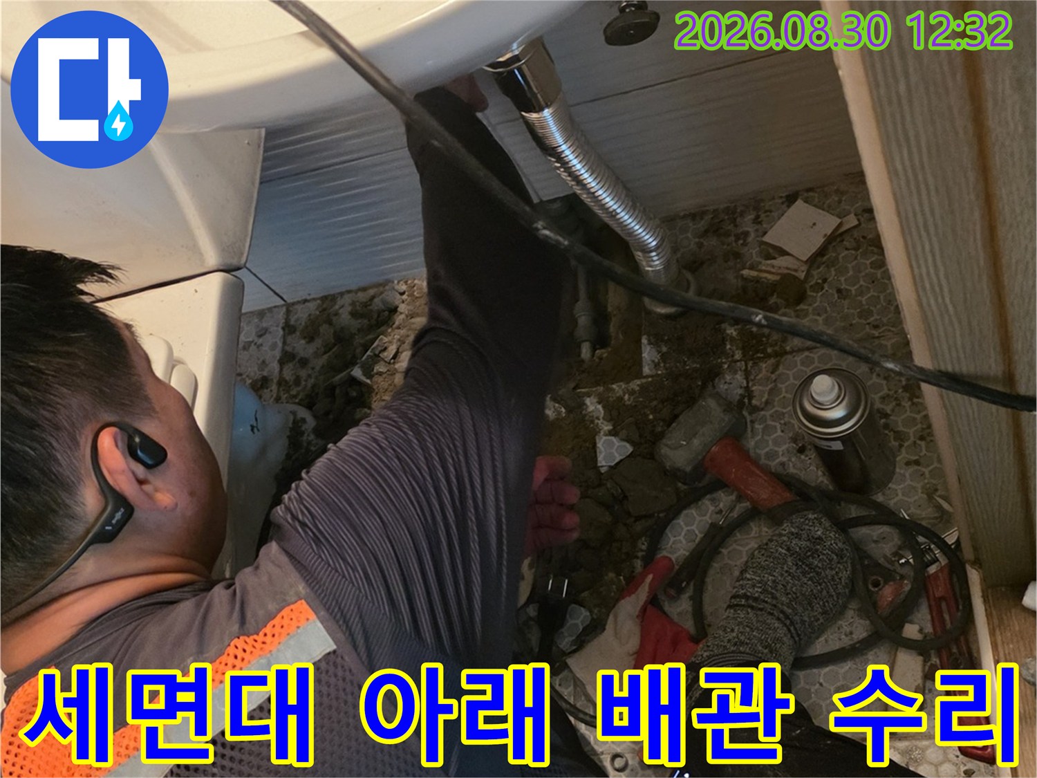 세면대 하부 굴착 부위에서 진행되는 배관 보수 작업 모습