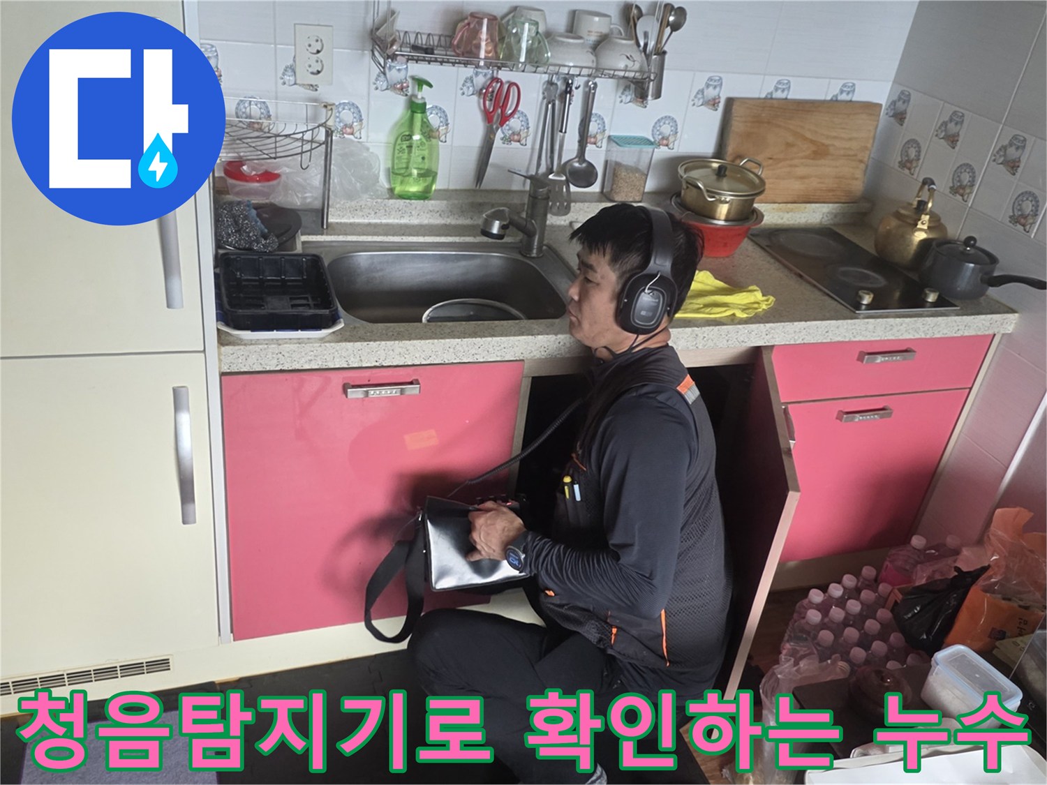 싱크대 하단에서 청음 탐지기를 사용하여 미세한 물 흐르는 소리를 추적하는 모습