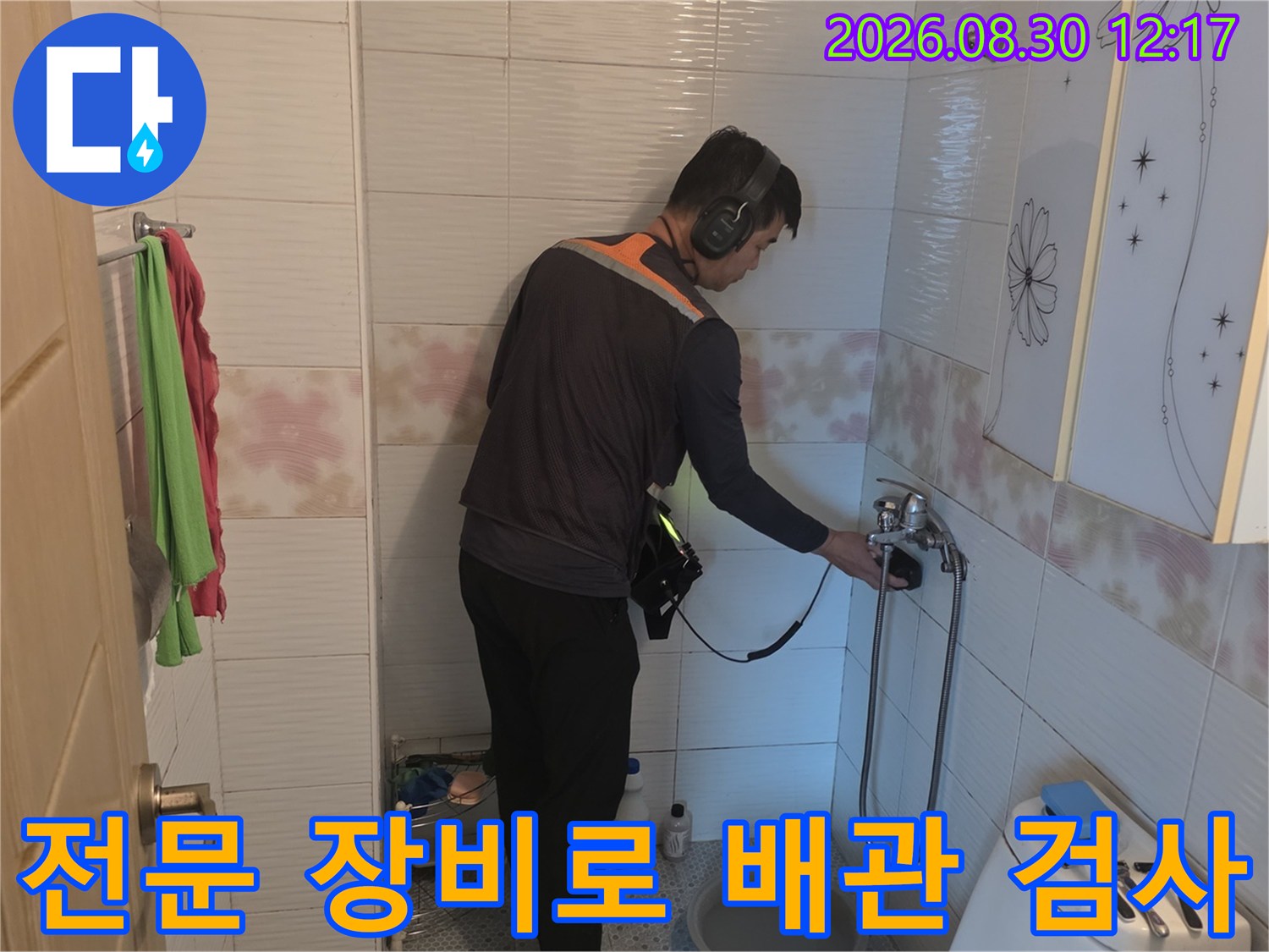 청음 탐지기를 사용하여-매립된 배관의 누수 지점을-추적하는 현장 사진입니다.