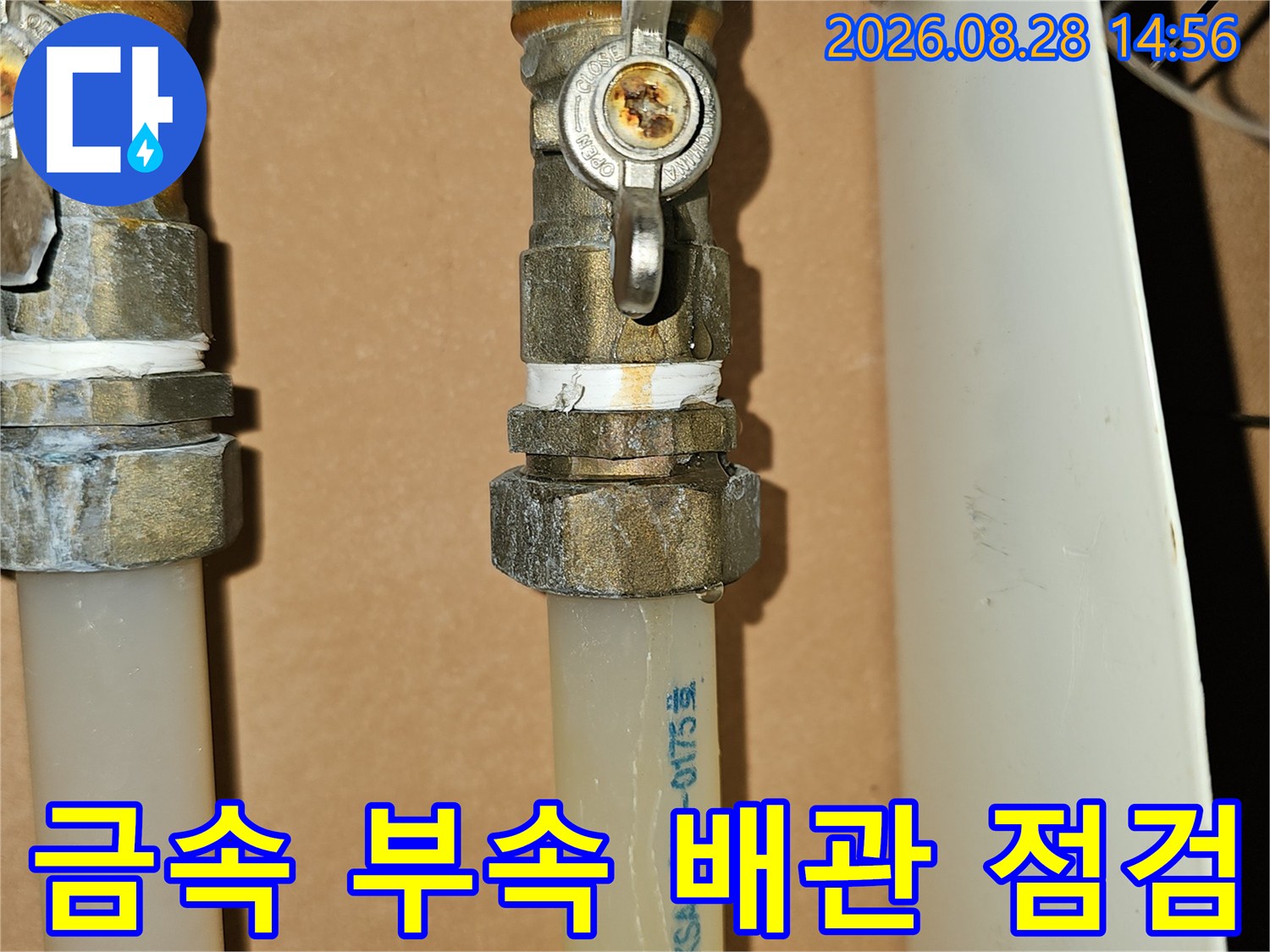 배관 연결 부위의 금속 조인트와 흰색 관 근접 사진