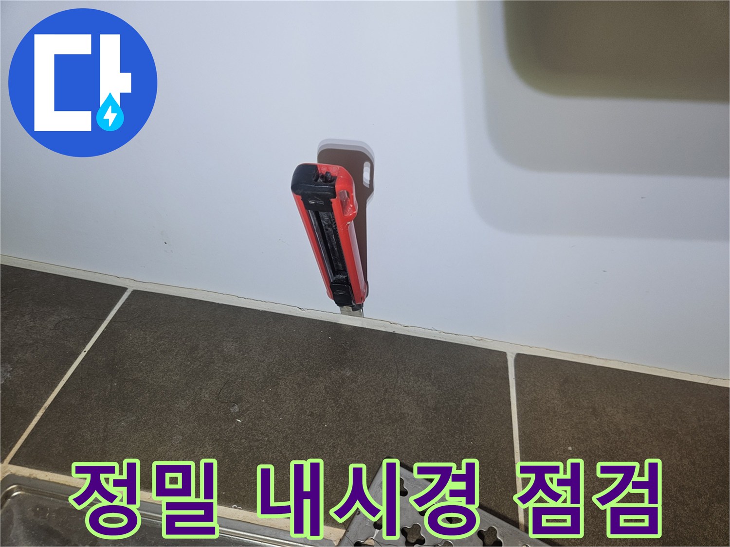 타공된 벽면 틈새로 삽입된 내시경 카메라 장비