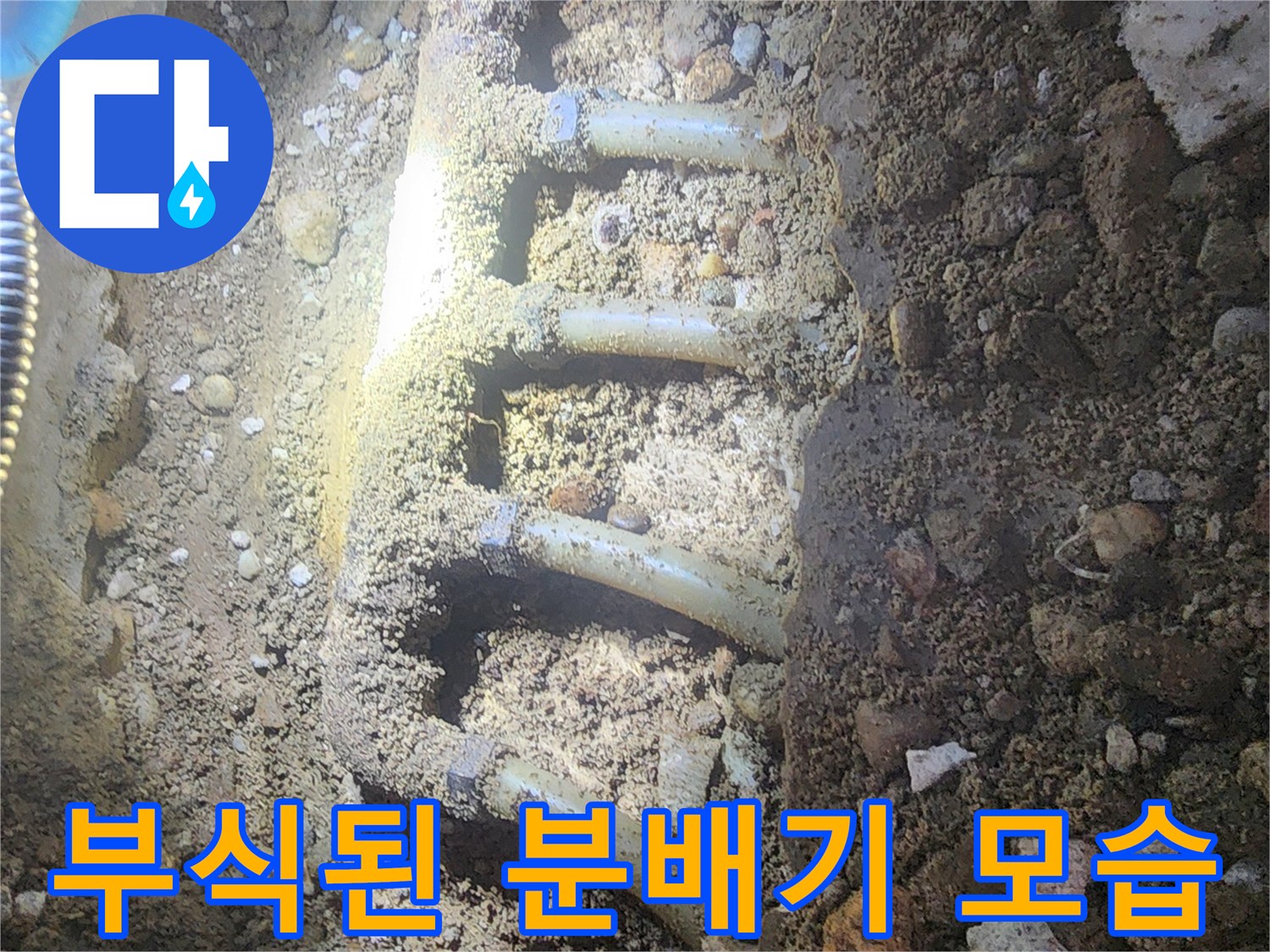 흙과 자갈 사이로 드러난 부식된 금속제 분배기 현장