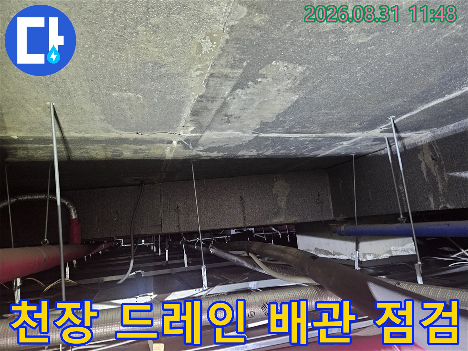 천장 내부의-에어컨 드레인 배관과 연결된 호스들을 보여줍니다.