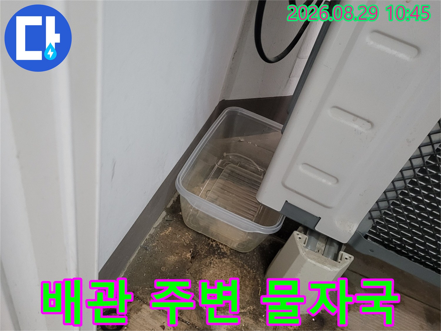 세탁기 하단 배관-주변 타일의 습기와 어두운 변색 부위