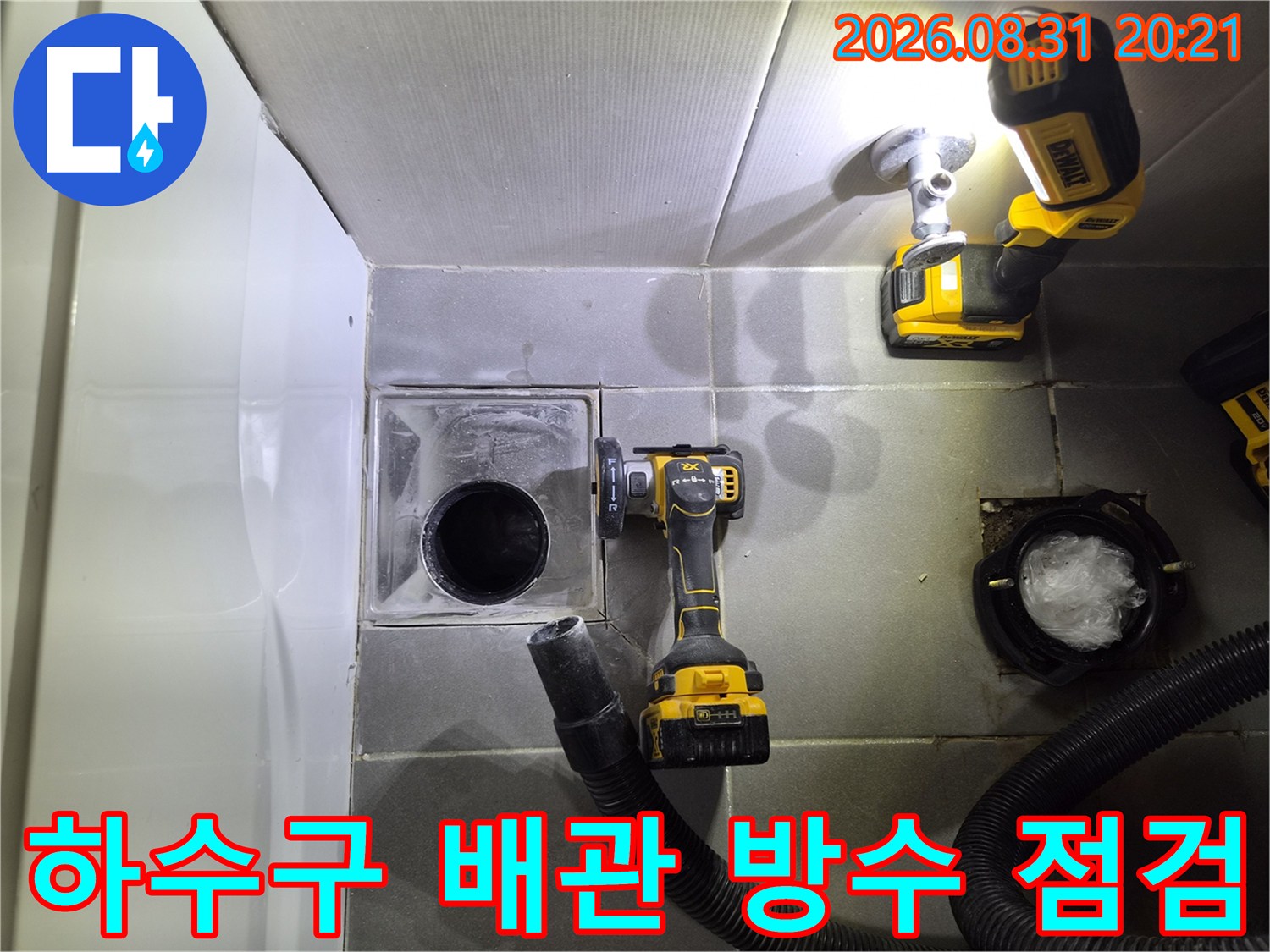 노출된 하수관 주변의 타일 상태와 작업 도구를 촬영한 사진입니다.