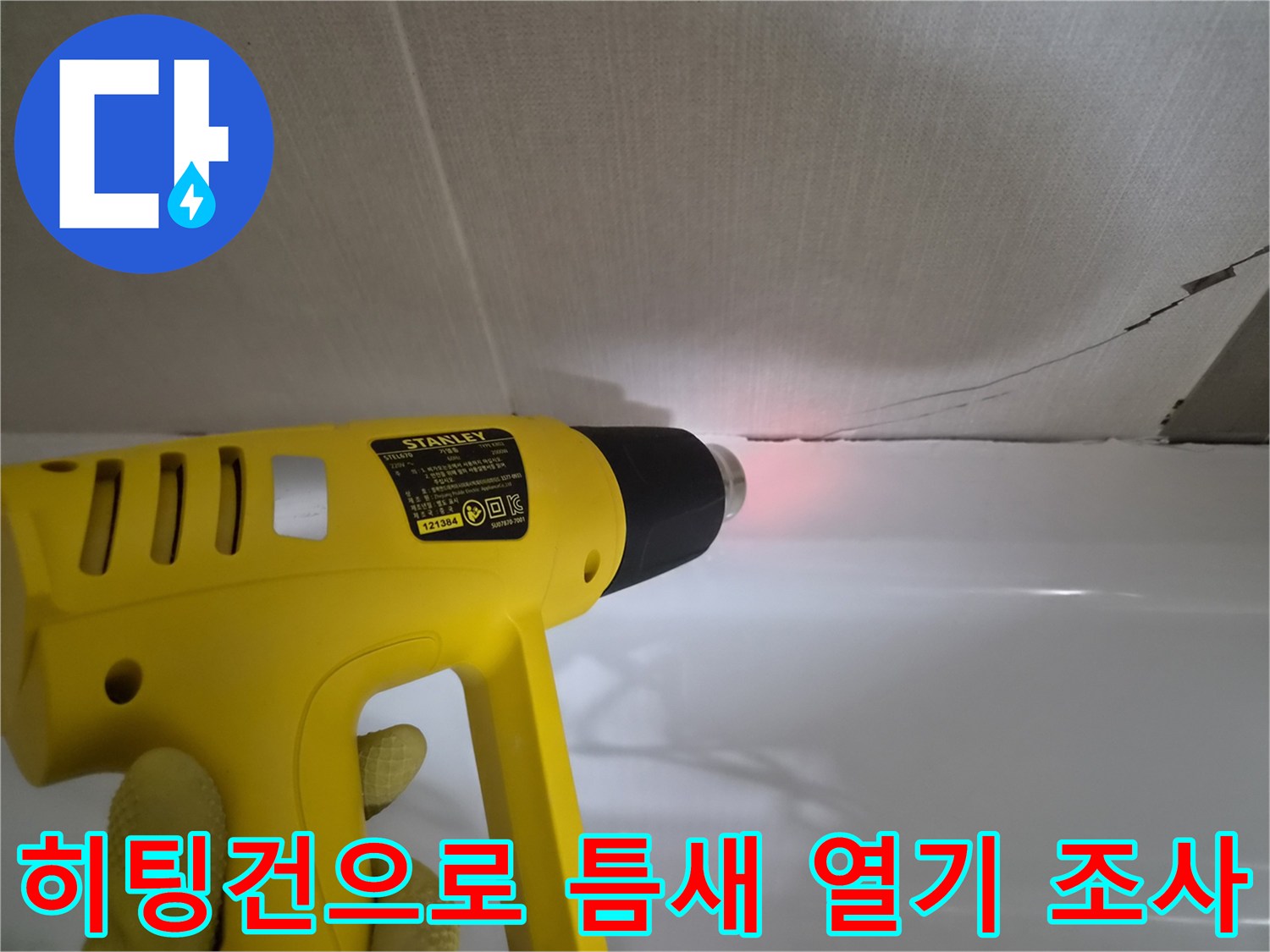 타일 사이 갈라진 부분에-히팅건을 사용하여 누수 여부를 확인하는 모습