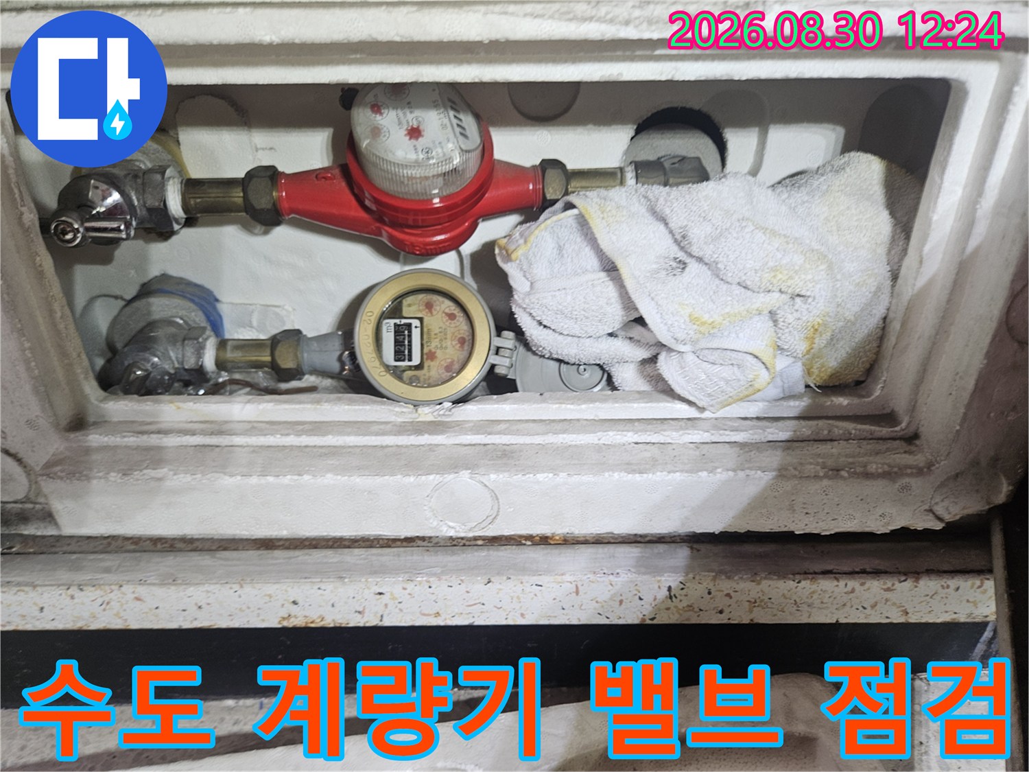 계량기함 내부에 설치된 수도 밸브와 금속 배관의 모습입니다.