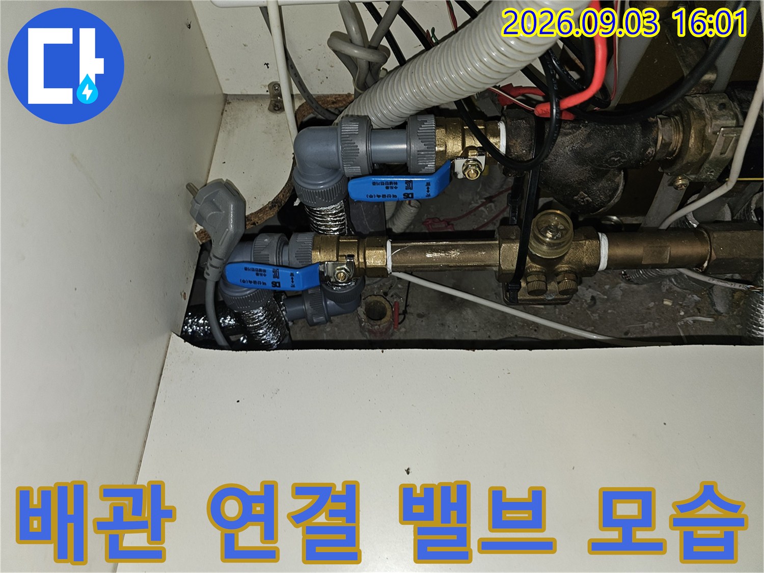 금속 배관과 파란색 제어 밸브가 결합된 배관 설비의 상세 사진입니다.