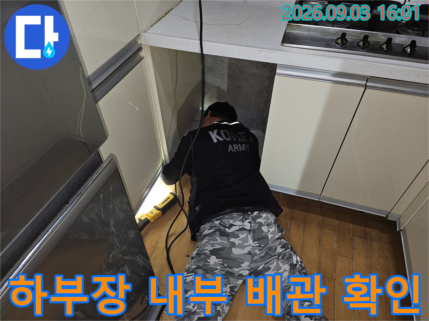 싱크대 하단 좁은 공간에 위치한 배관의 노후 상태를 점검하는 엔지니어