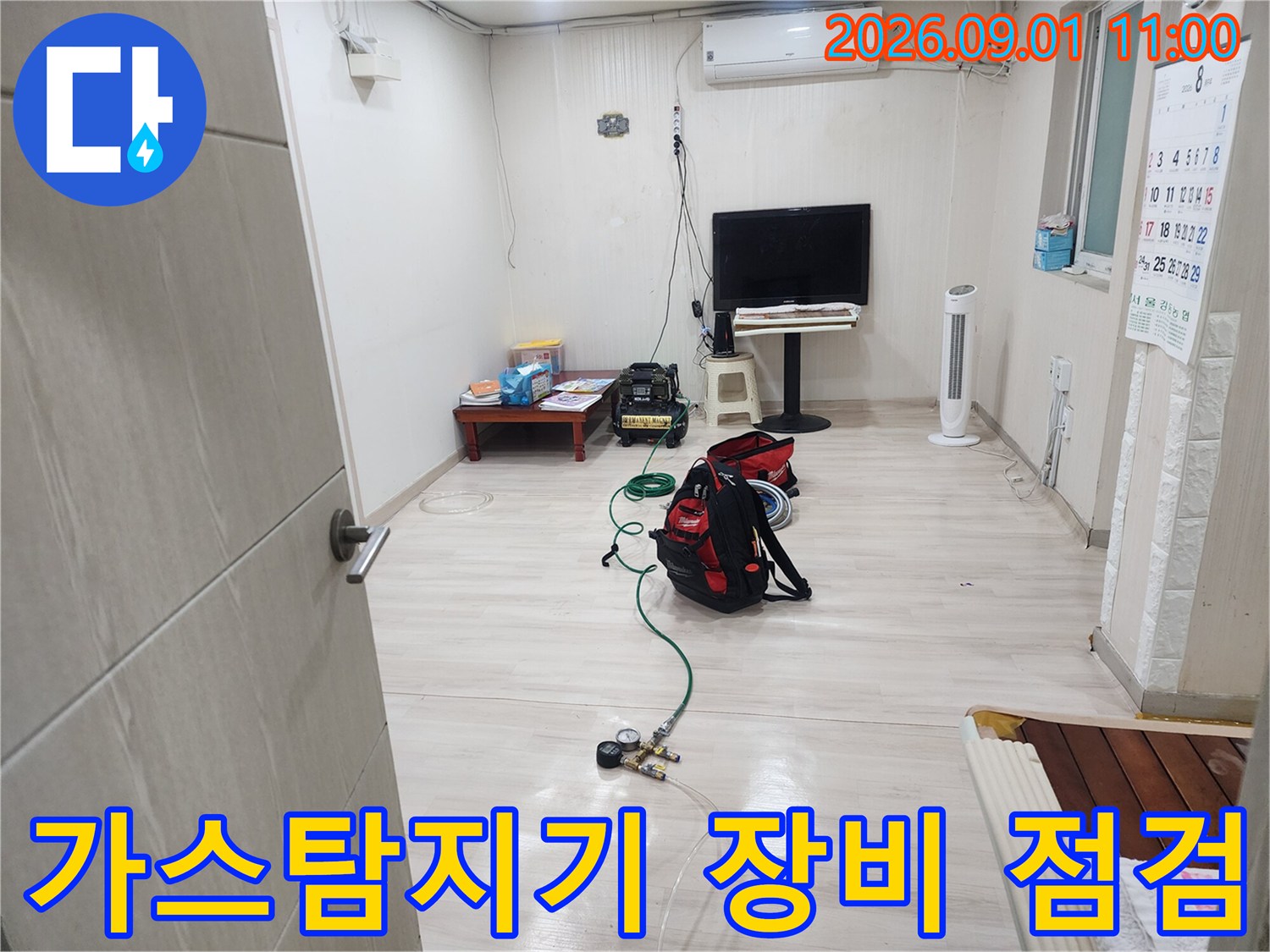 거실 바닥에 설치된 가스 탐지 장비와 배관 검사 중인 모습
