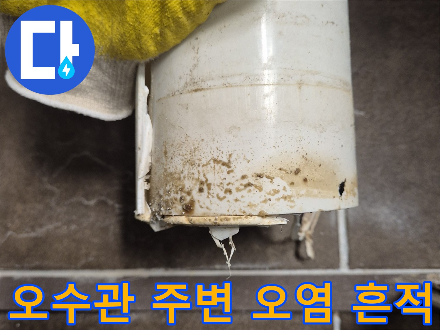변기 배관 연결부의 누출로 인해 변색된 타일과 배관 상태