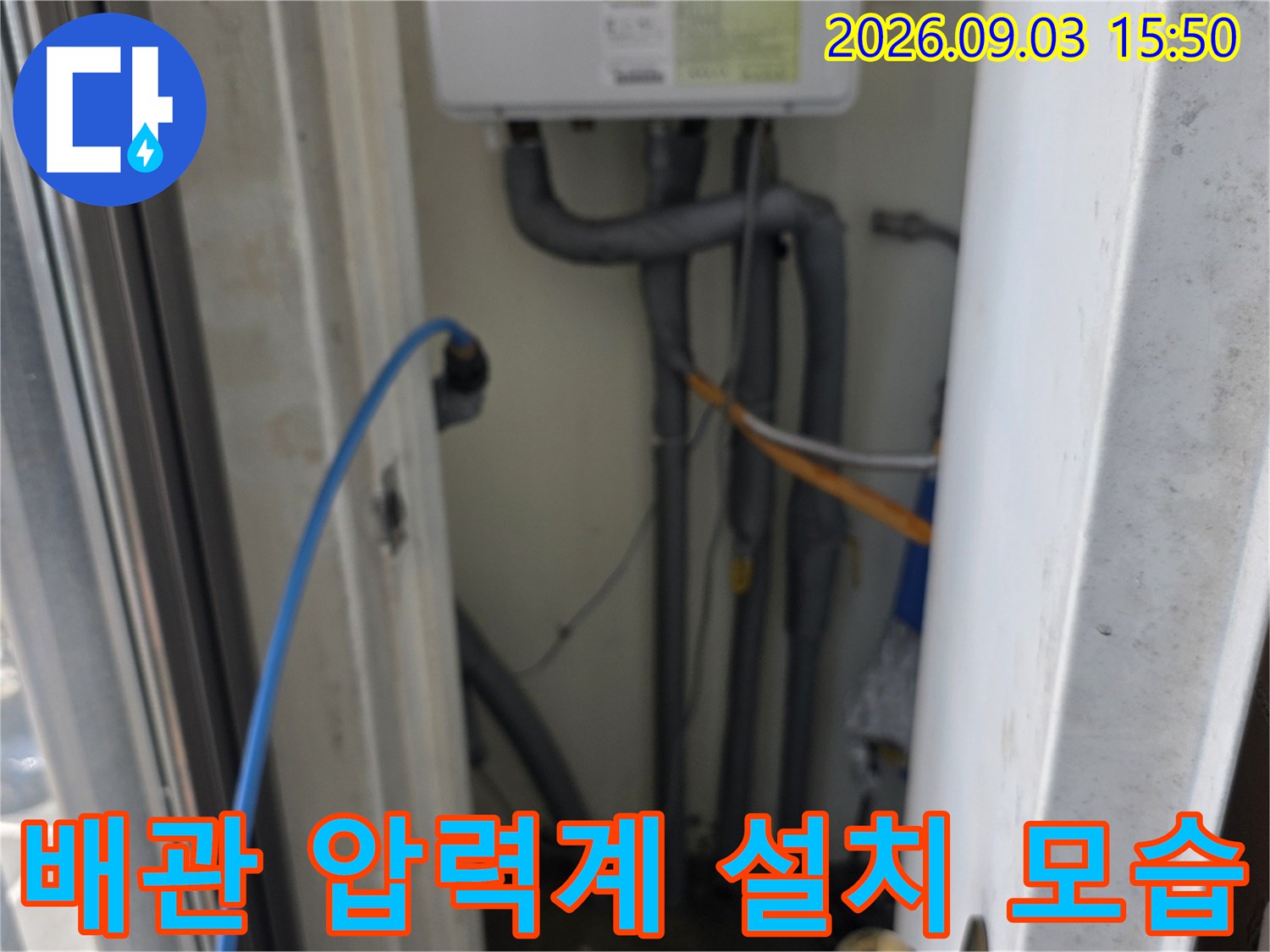 베란다 배관 라인에 연결된 파란색 호스와 검사 장비입니다.