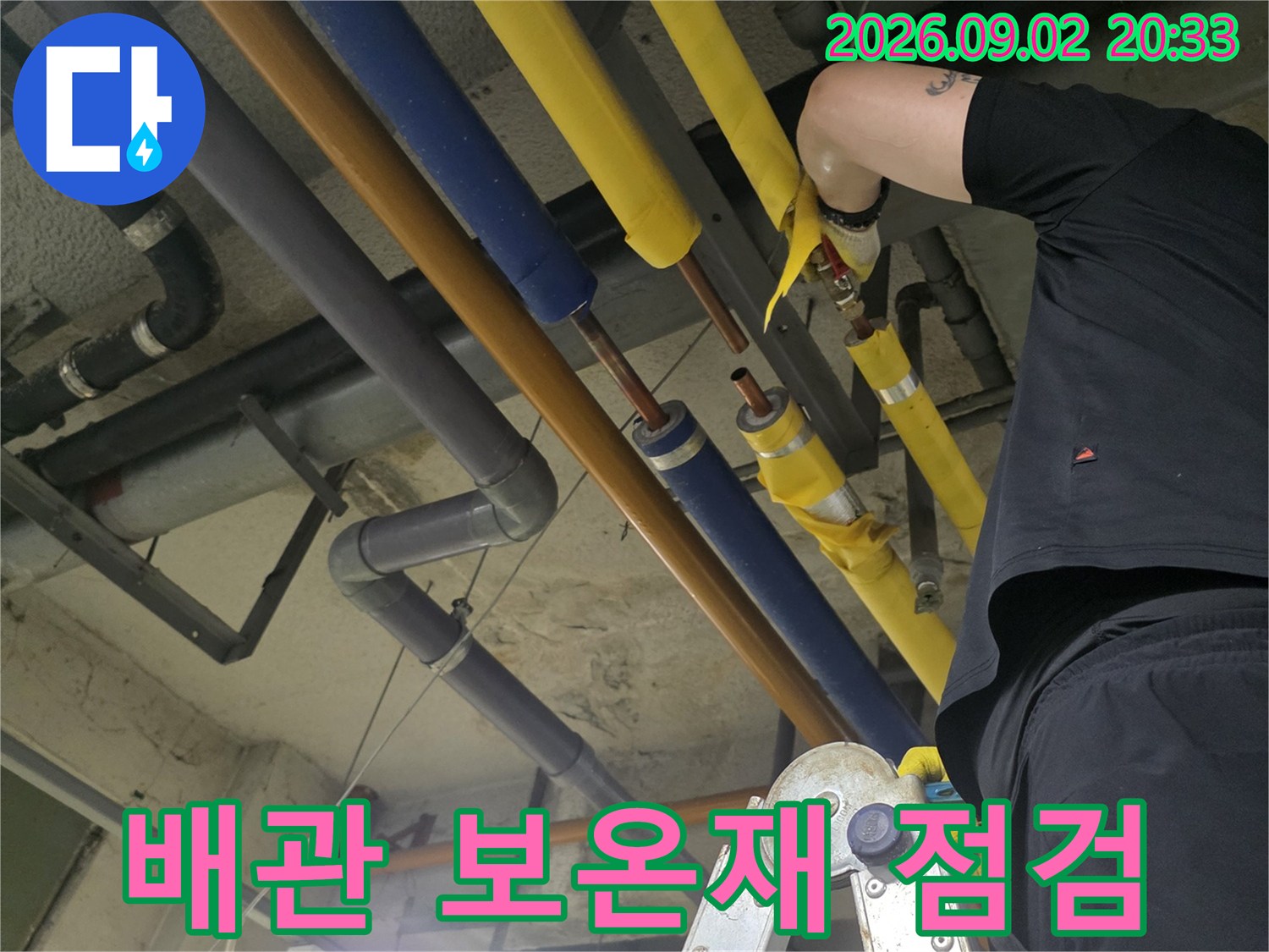 천장 배관의-연결 부위 누수를 확인하기 위해 근접하여 작업 중입니다.