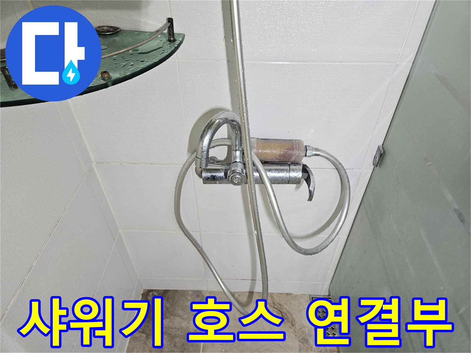벽면에 고정된 샤워기 수전과 호스의 연결 상태 사진