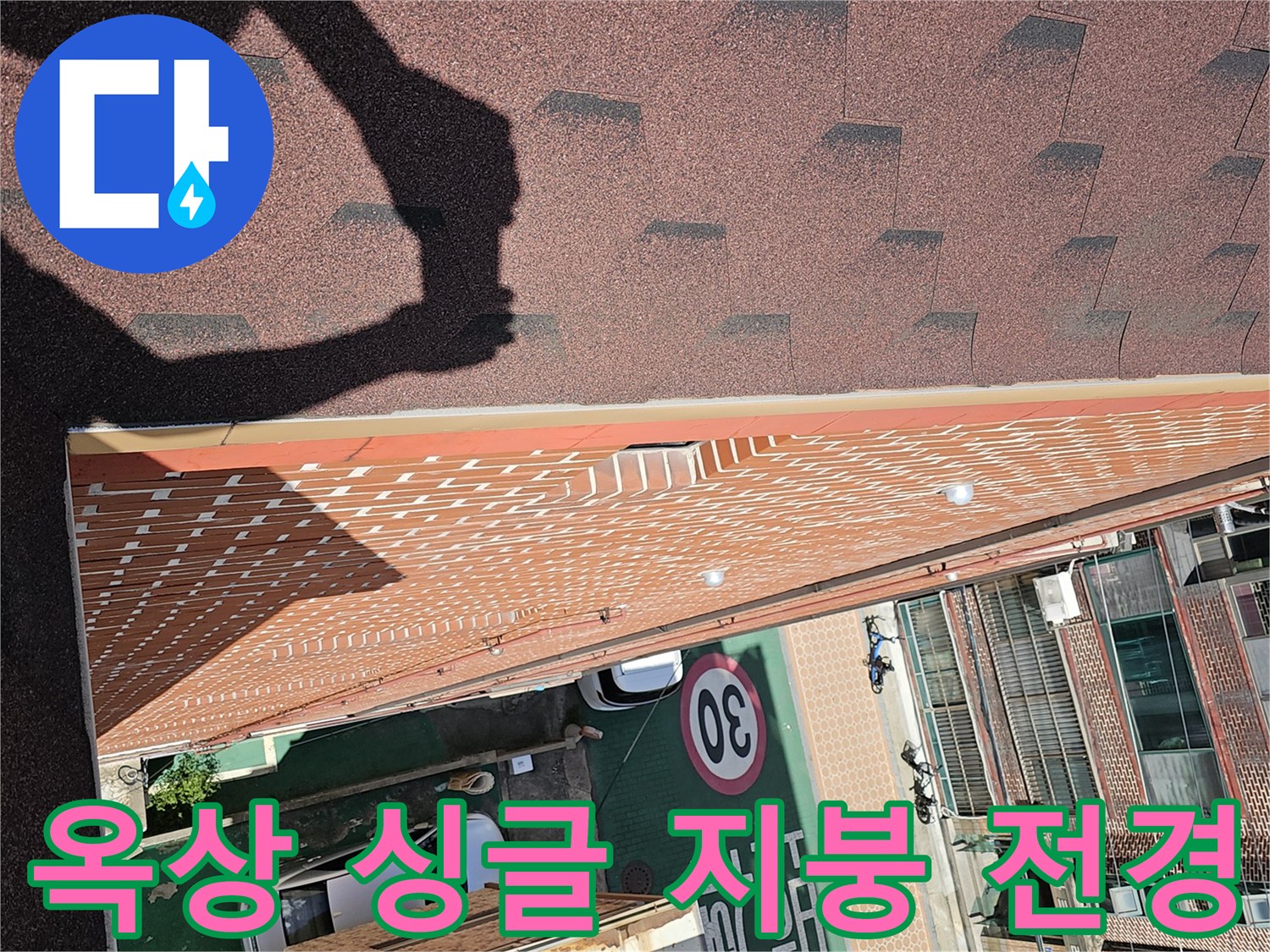 건물 옥상의 아스팔트 싱글과 인접한 외벽 구조물 사진