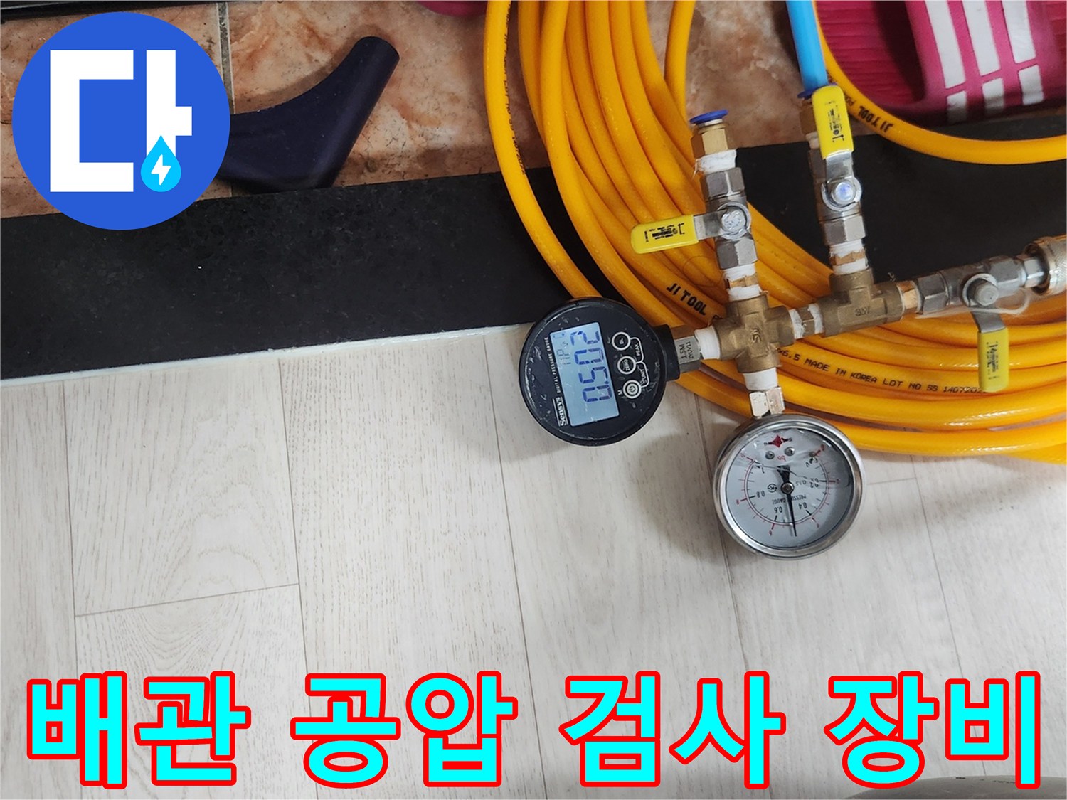 노란색 호스와 압력 게이지가 연결된 수도 배관 공압 검사 장비 모습