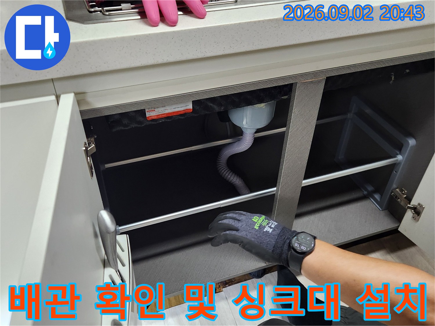 싱크대 밑 배수 호스 연결 부위를 점검하며 하부장을 재조립합니다.