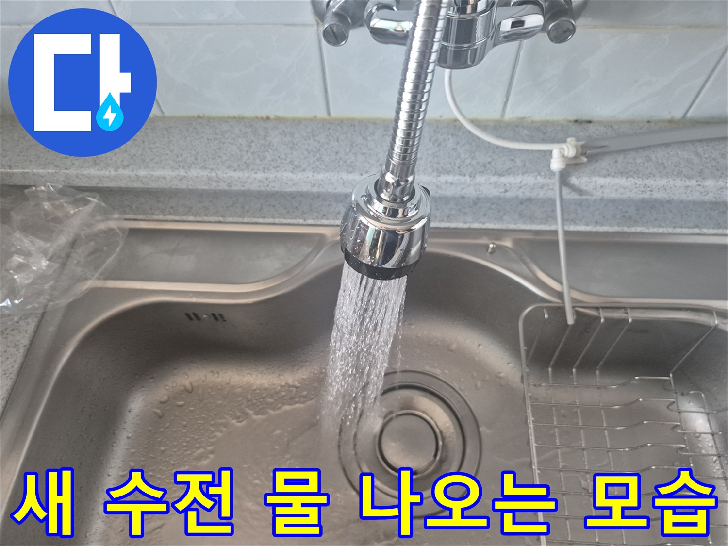 새로 설치된 싱크대 수전에서 시원하게 물이 뿜어져 나오는 장면입니다.