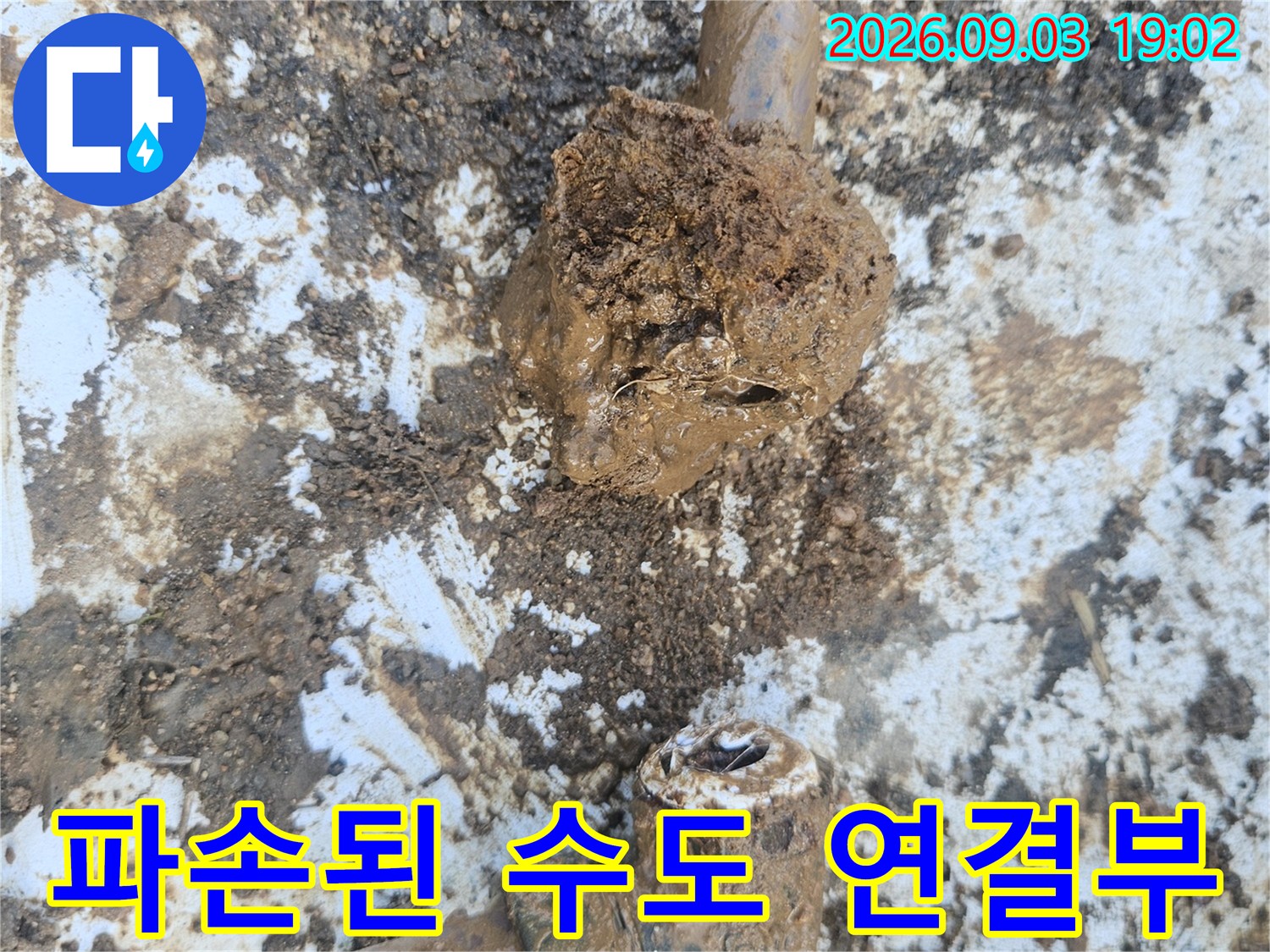 흙과 오물이 묻은-누수가 발생한 수도 배관의 엘보우 부속 상세 사진입니다.