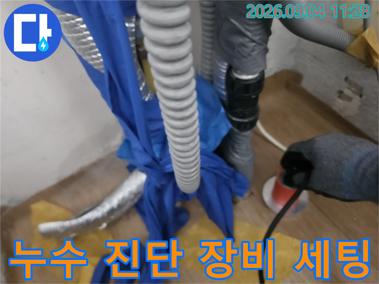 누수 지점을 찾기 위해 배관 주변에 점검용 호스와 장비를 설치했습니다.