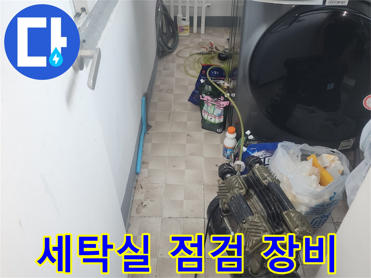 세탁기 옆에 놓인 공기 압축기와 점검용 호스