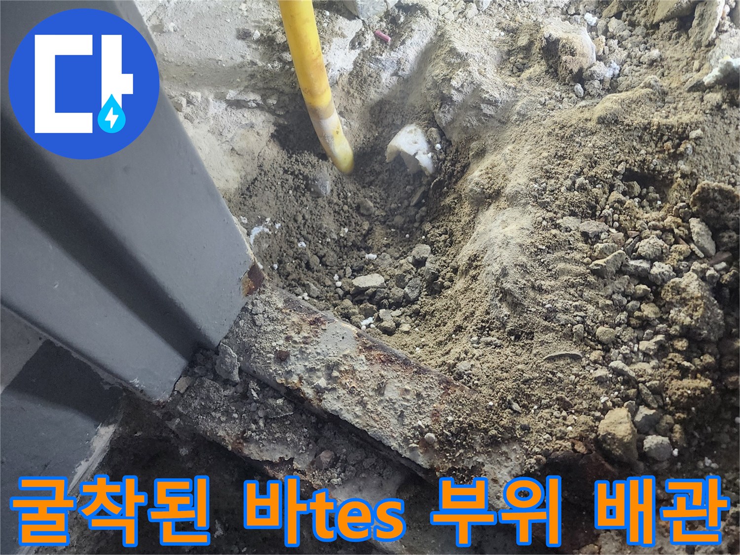 콘크리트 파쇄 후 드러난 노란색 배관과 흙