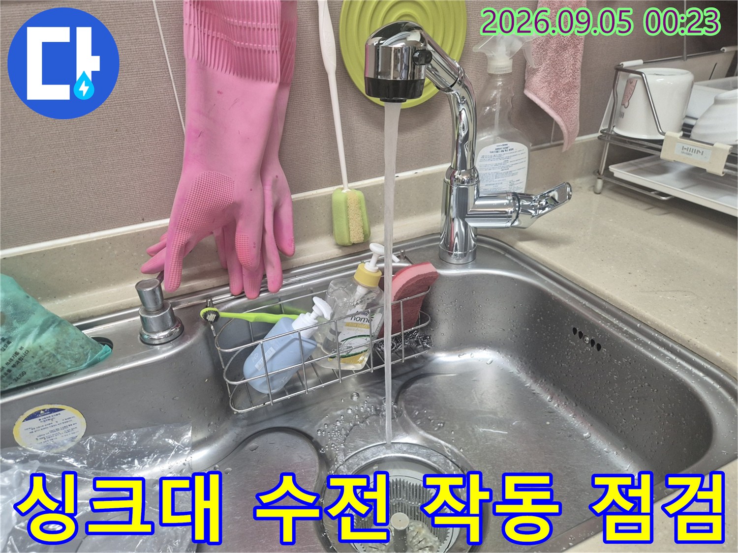 교체 작업이 끝난 싱크대 수전에서 물을 틀어 배수 상태를 점검하고 있습니다.