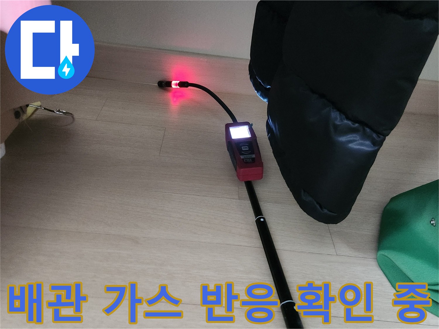붉은 빛을 띠는 가스 탐지 센서가 배관 누수 지점을 가리키고 있는 모습입니다.