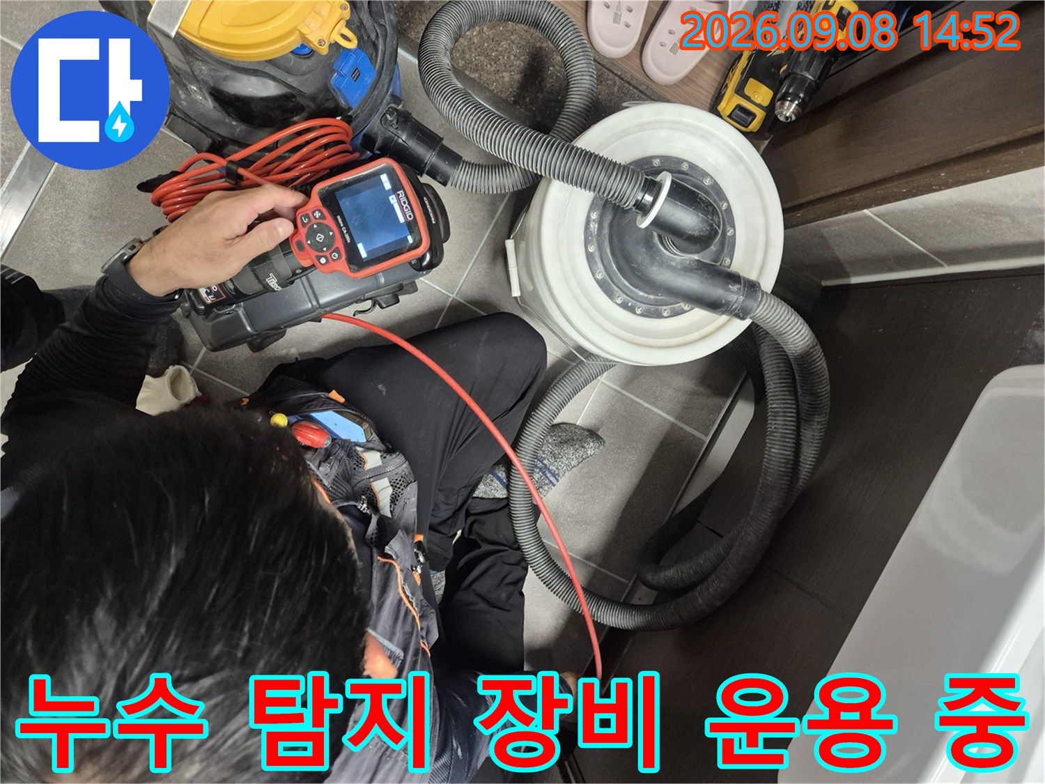 배관 탐지기와 연결된 호스를 이용해 욕실 내부의 누수를 점검하는 모습입니다.